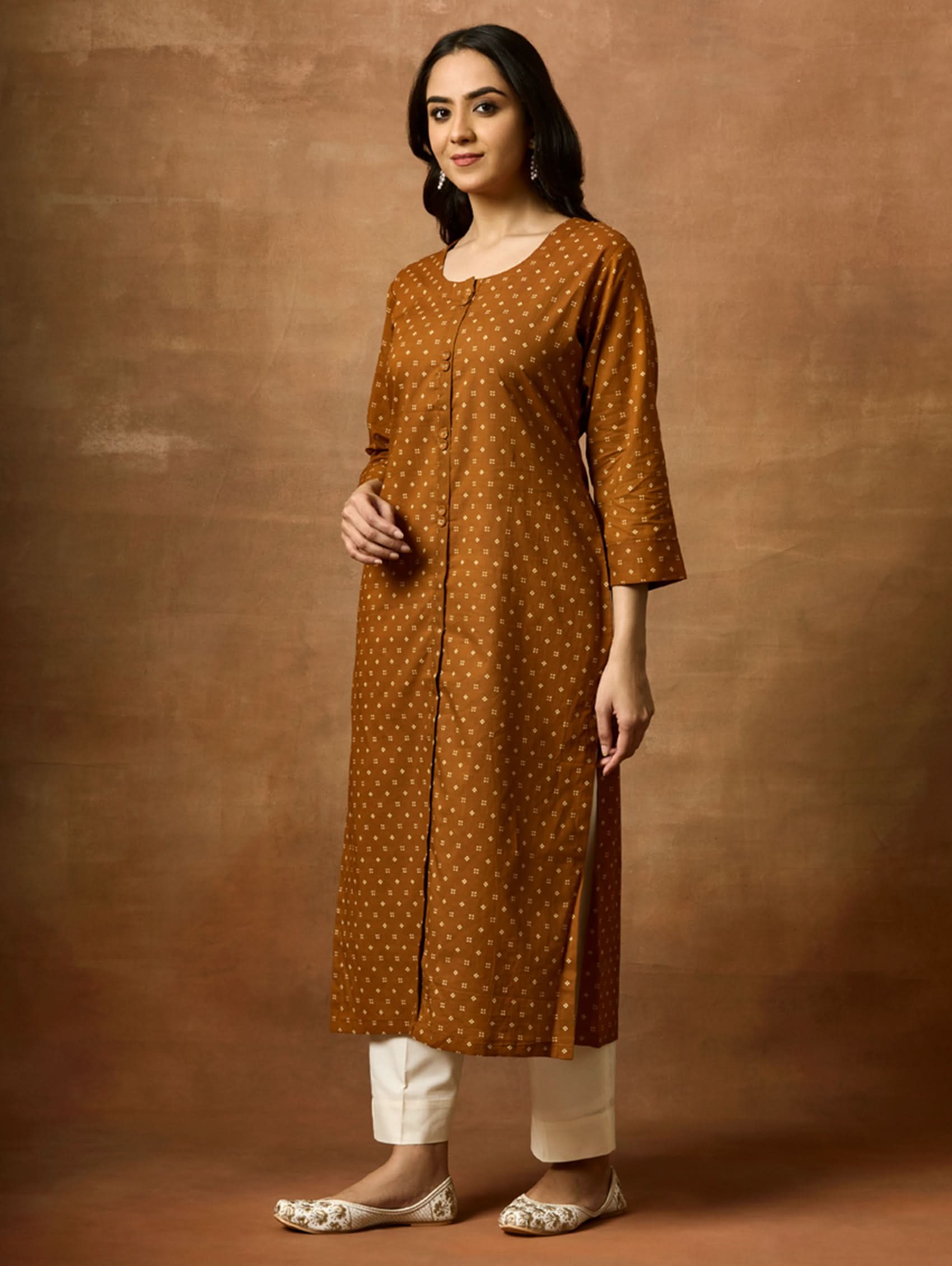Woman wearing a brown polka dot kurta against a brown background