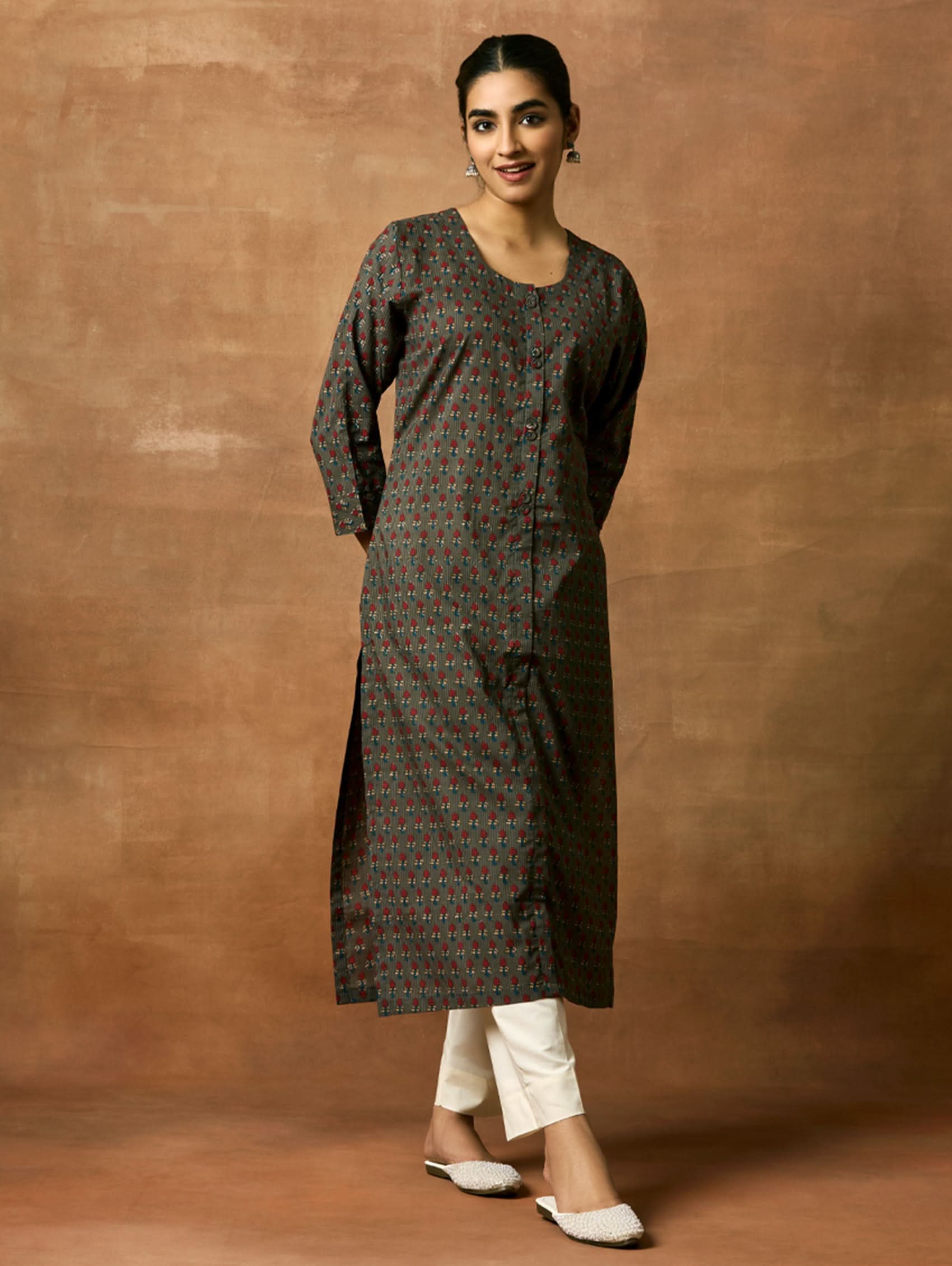 A woman plus size model wearing a printed pure cotton kurta with round neckline, three-fourth sleeves, and side slits. The kurta is in shades of gray and blue with a geometric pattern.