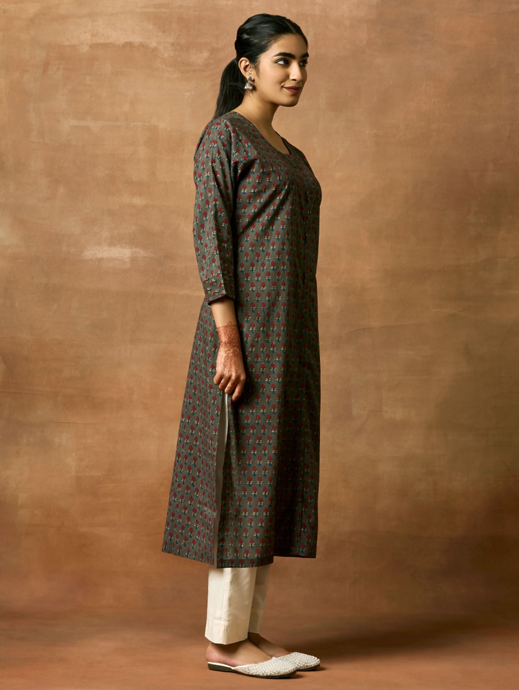 A woman plus size model wearing a printed pure cotton kurta with round neckline, three-fourth sleeves, and side slits. The kurta is in shades of gray and blue with a geometric pattern.