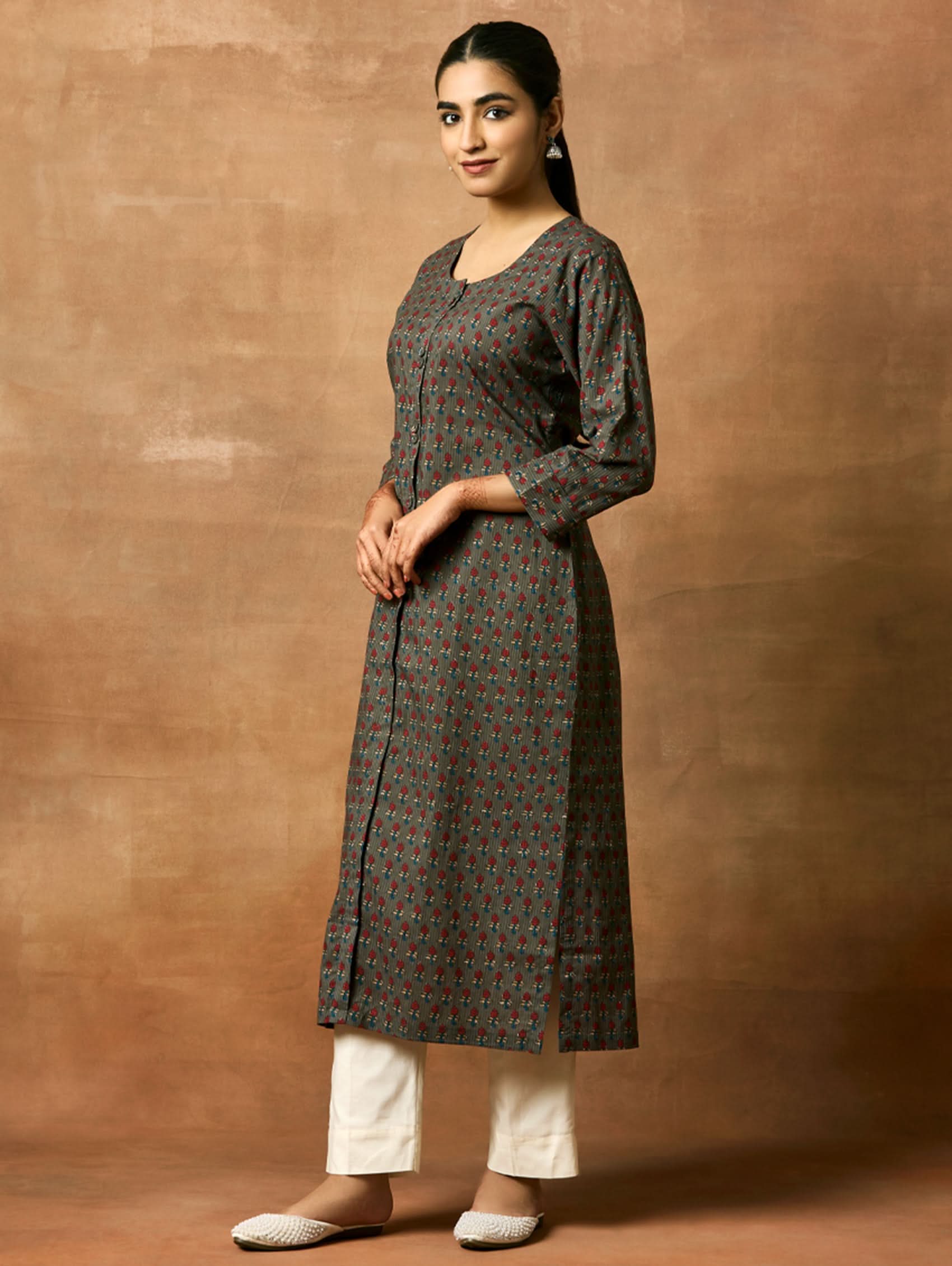 A woman plus size model wearing a printed pure cotton kurta with round neckline, three-fourth sleeves, and side slits. The kurta is in shades of gray and blue with a geometric pattern.