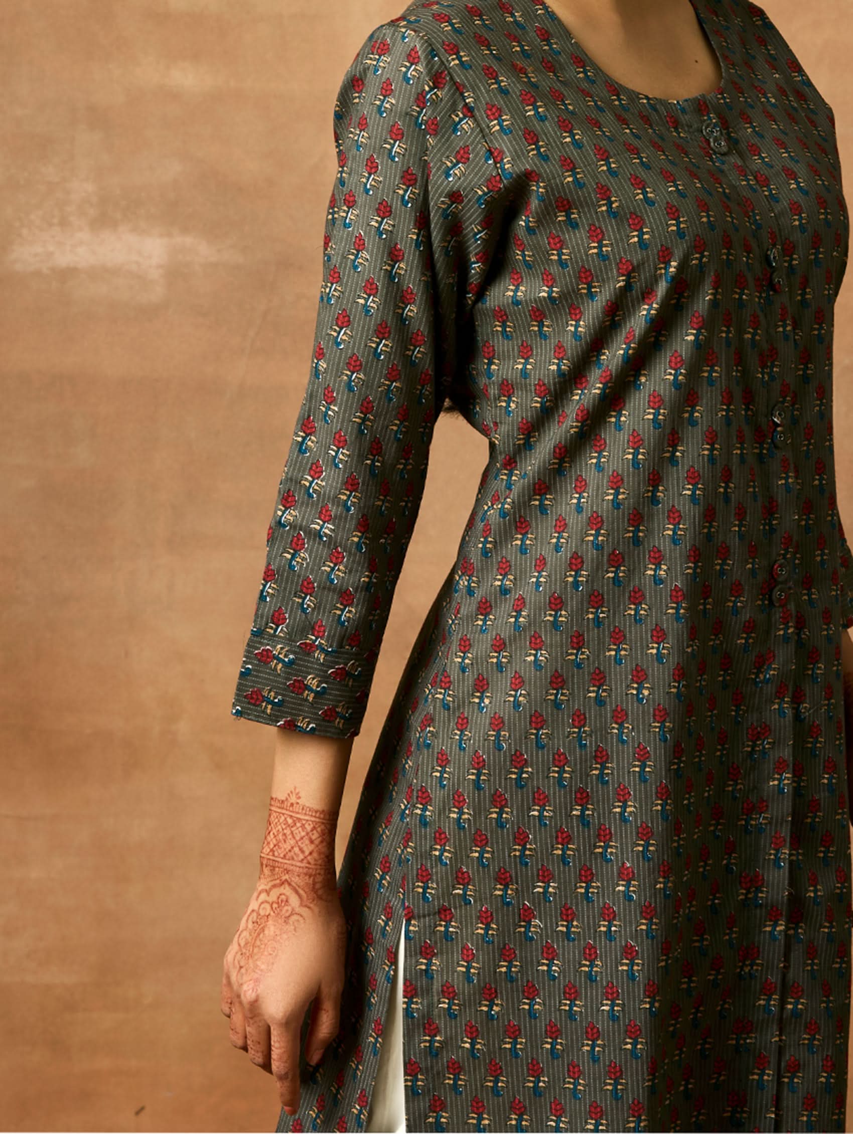 A woman plus size model wearing a printed pure cotton kurta with round neckline, three-fourth sleeves, and side slits. The kurta is in shades of gray and blue with a geometric pattern.