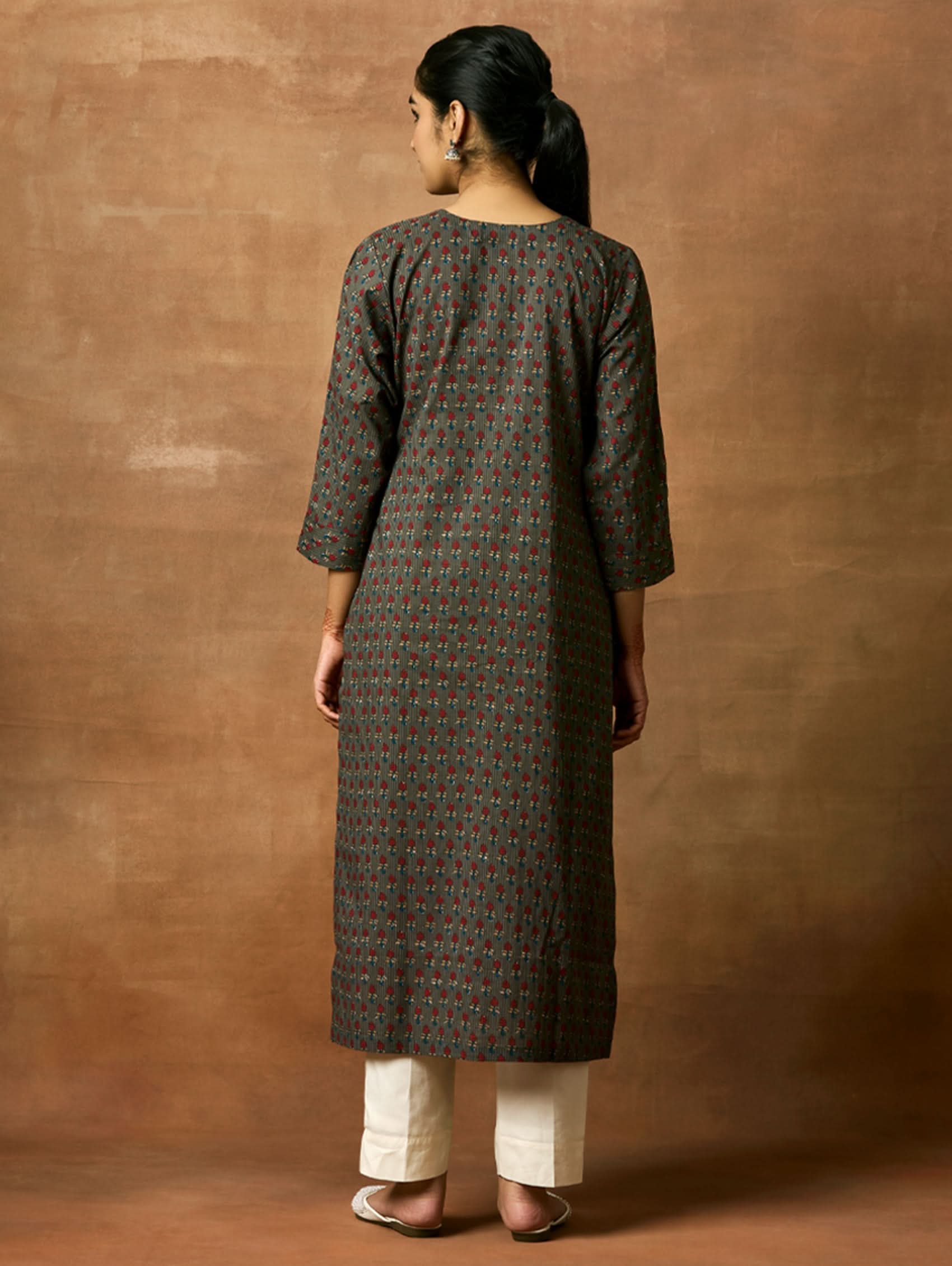 A woman plus size model wearing a printed pure cotton kurta with round neckline, three-fourth sleeves, and side slits. The kurta is in shades of gray and blue with a geometric pattern.