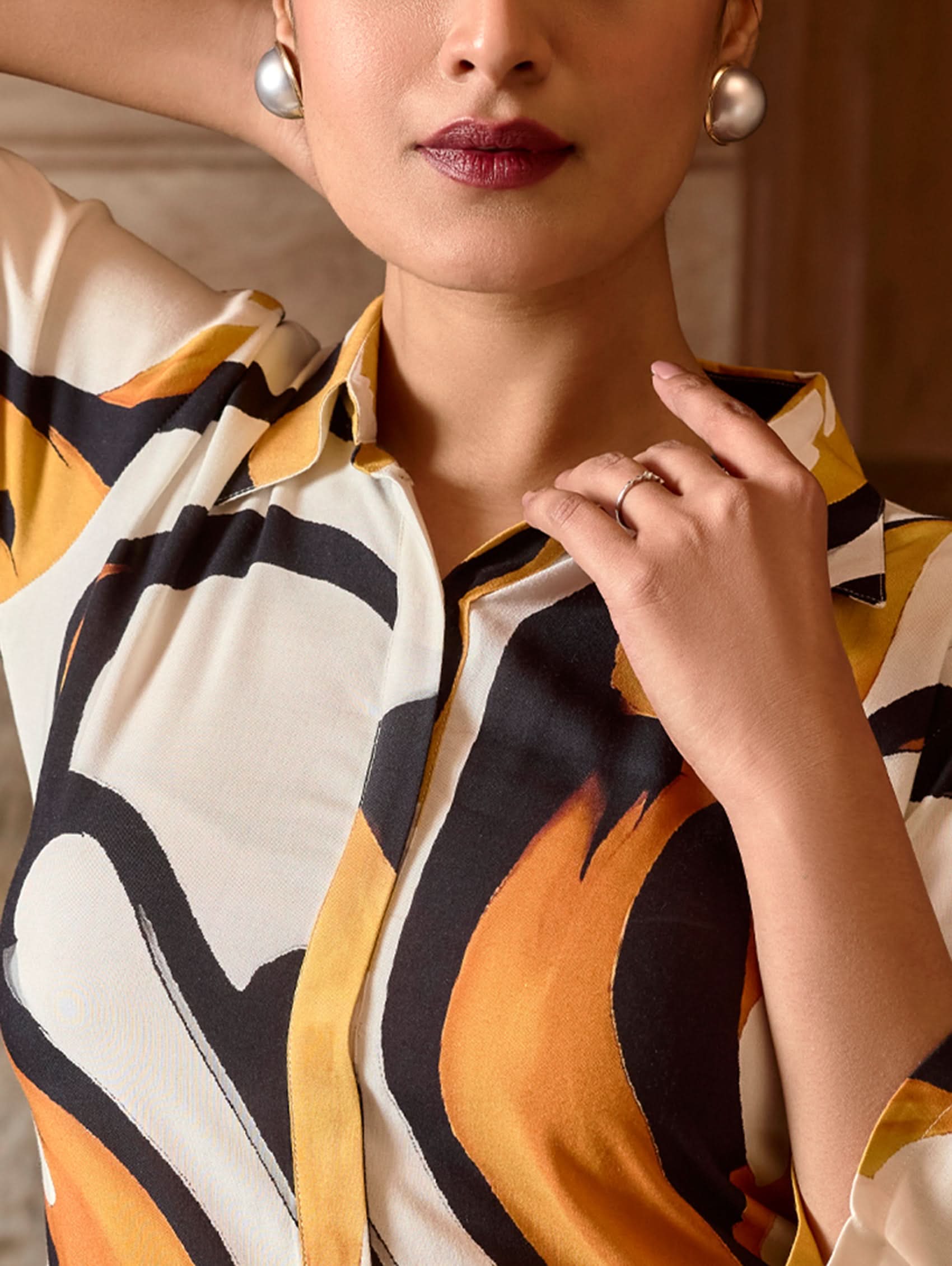 A model wearing a short kurta with a revere collar and three-fourth sleeves, paired with pants that have partially elasticated waistband and pockets on either side. The fabric is digitally printed viscose rayon.