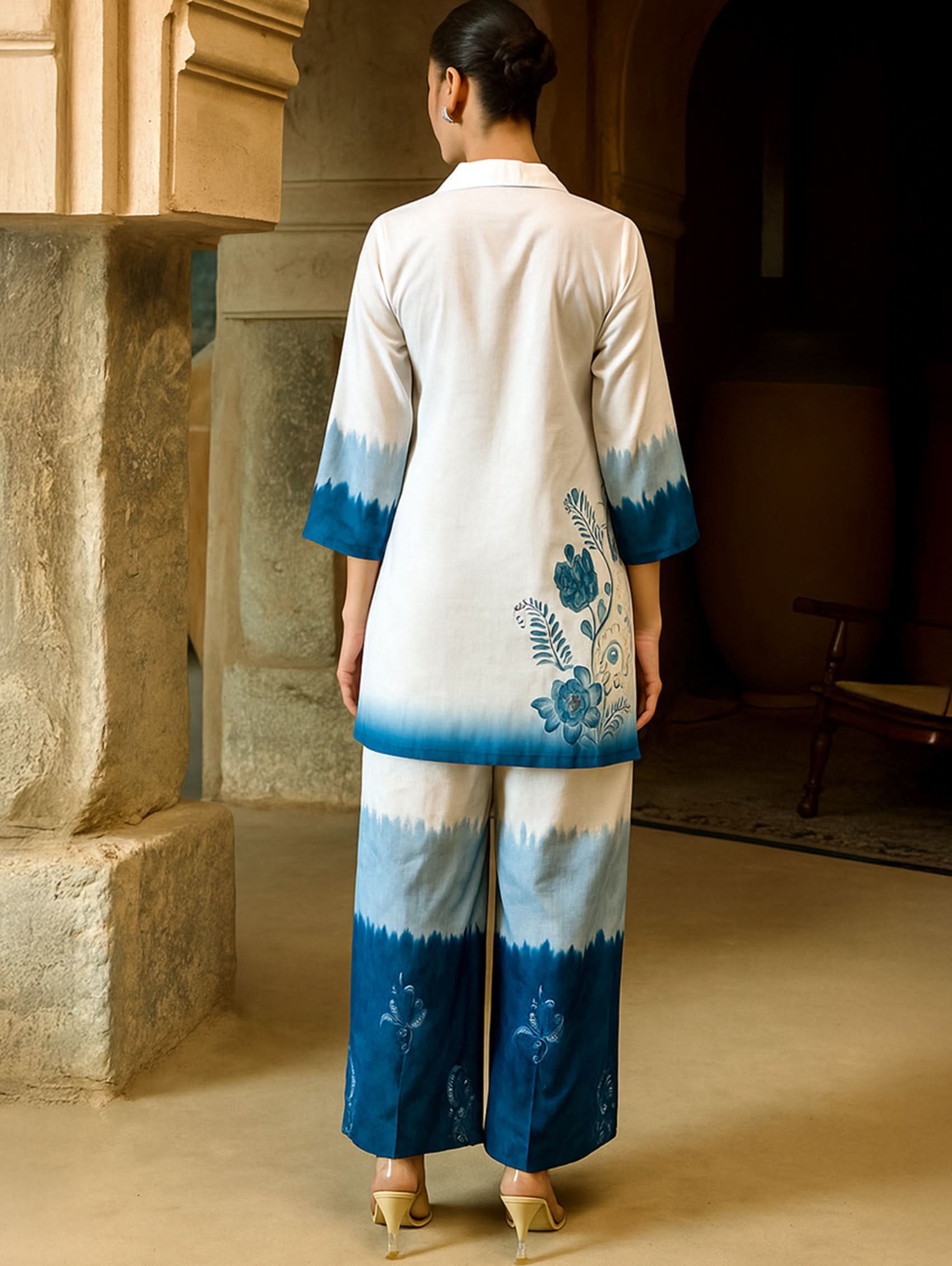 Person wearing a blue and white outfit with floral patterns in an indoor setting.
