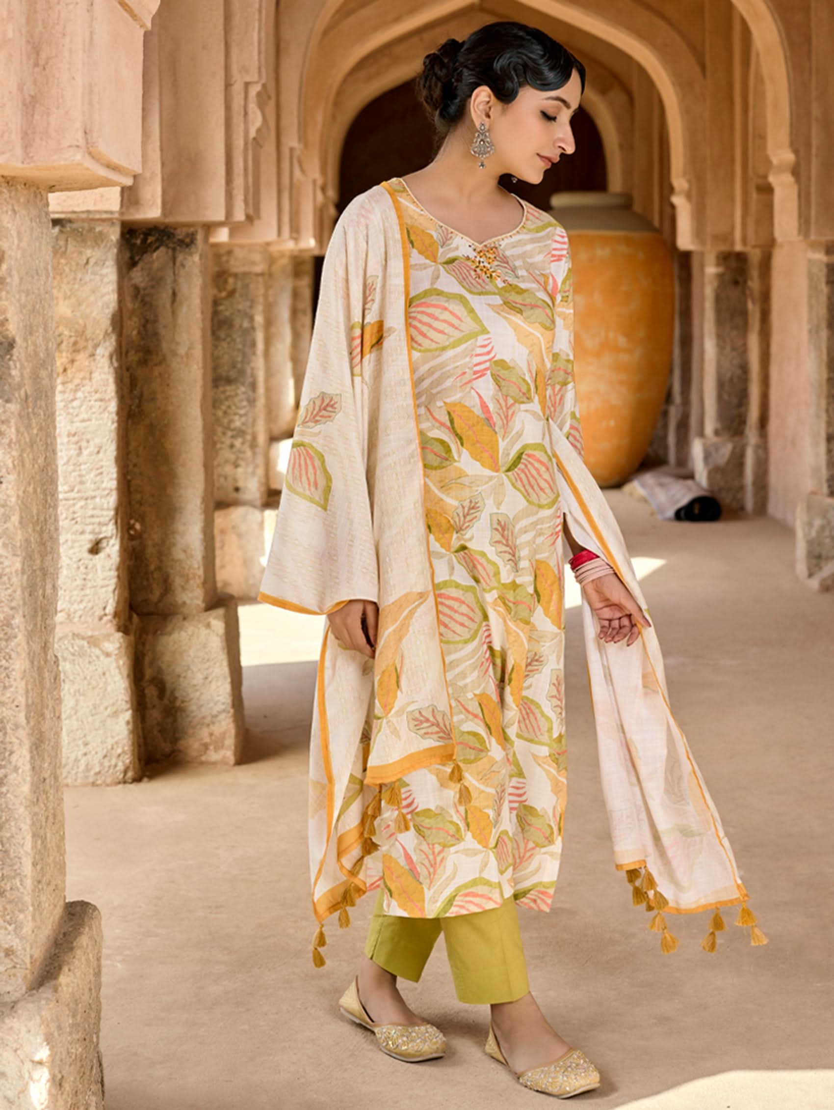 Woman in traditional outfit with floral dupatta in architectural setting