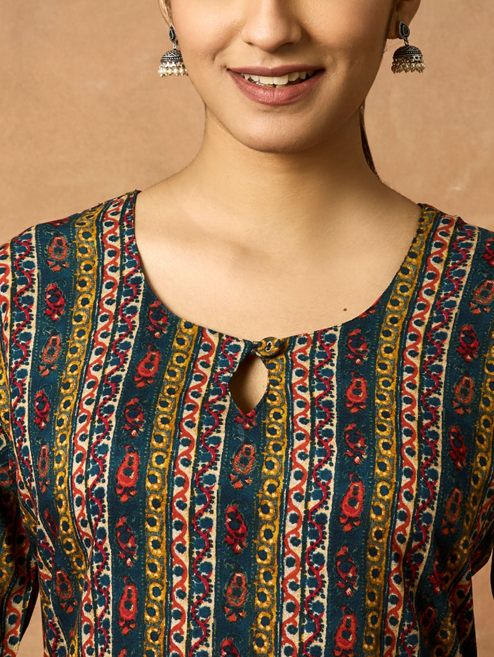 A woman plus size model wearing a printed viscose rayon kurta with a keyhole round neckline, three-fourth sleeves, and side slits. The kurta is in shades of blue and yellow.