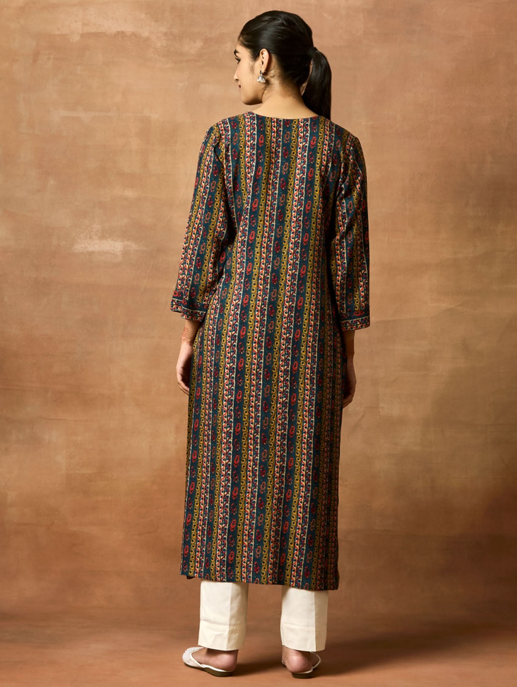 A woman plus size model wearing a printed viscose rayon kurta with a keyhole round neckline, three-fourth sleeves, and side slits. The kurta is in shades of blue and yellow.