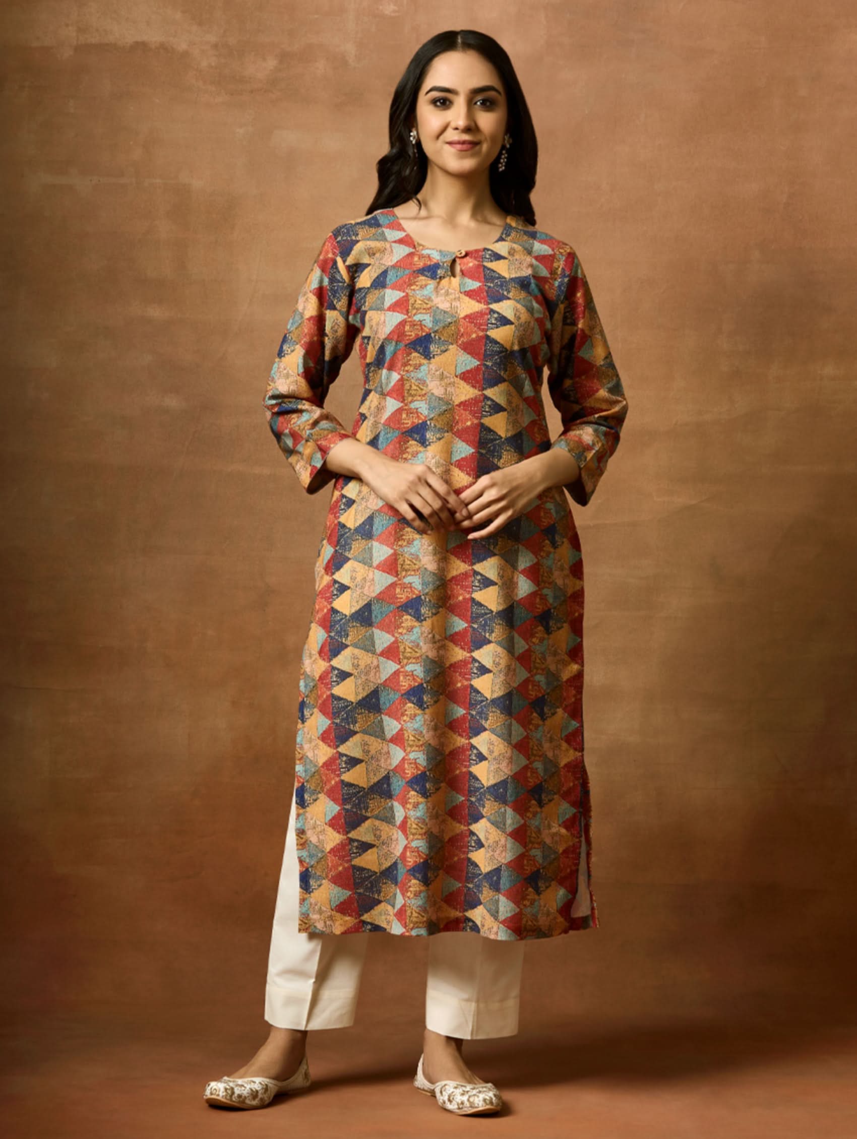 A woman plus size model wearing a multicolored geometric patterned kurta with round neckline and three-fourth sleeves.