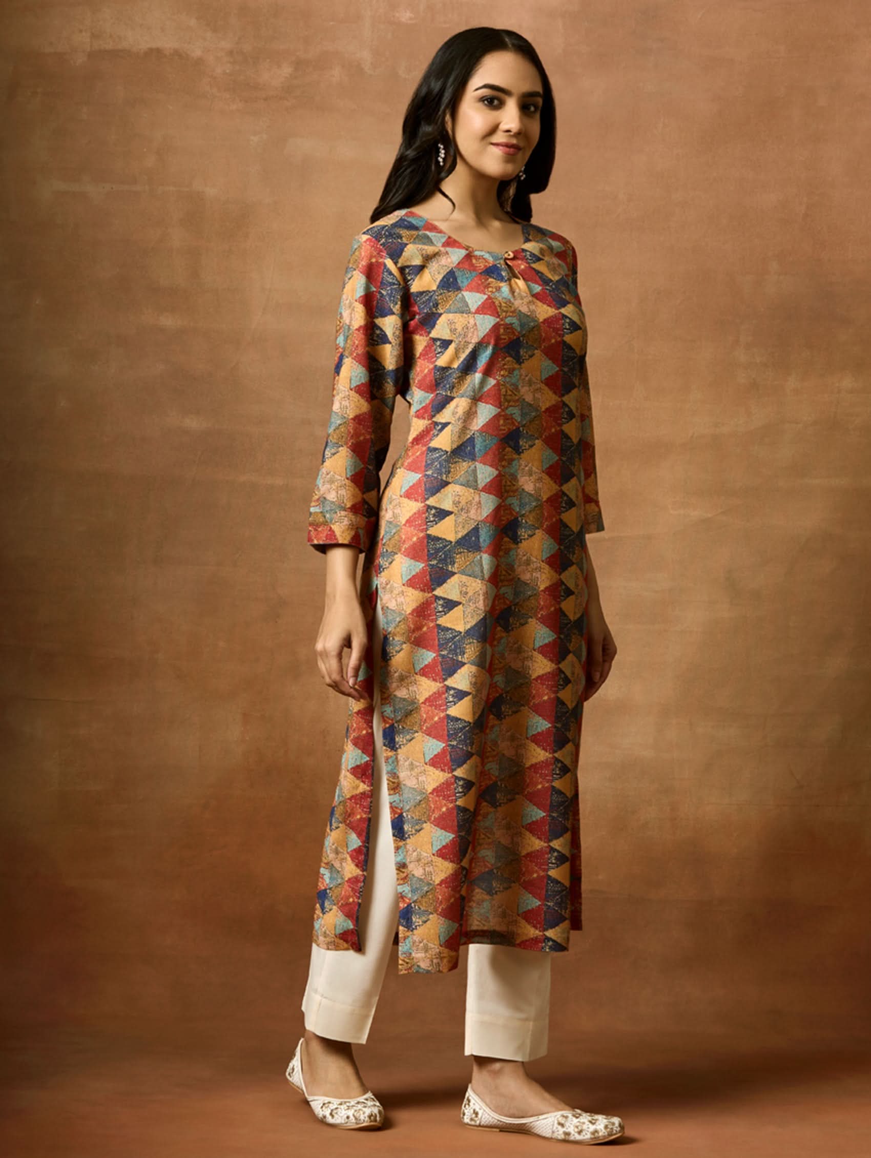 A woman plus size model wearing a multicolored geometric patterned kurta with Keyhole round neckline and three-fourth sleeves.