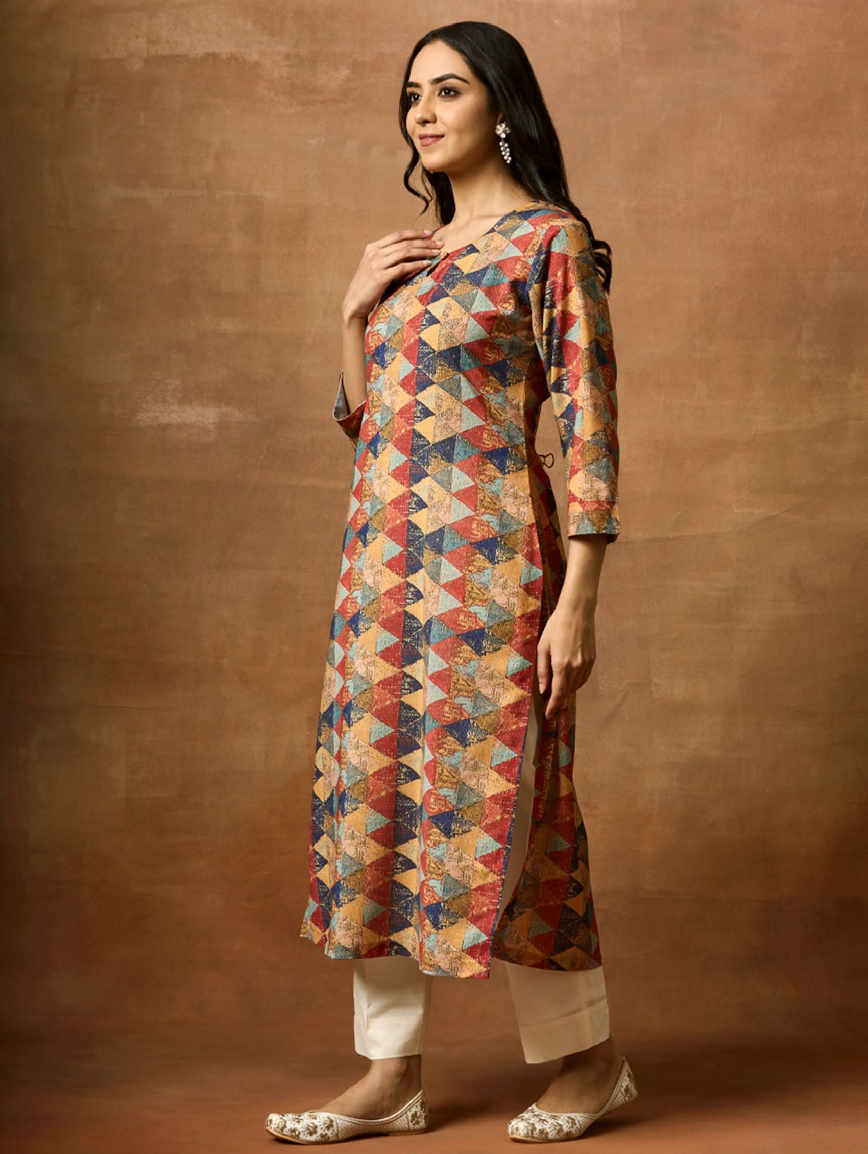 A woman plus size model wearing a multicolored geometric patterned kurta with Keyhole round neckline and three-fourth sleeves.