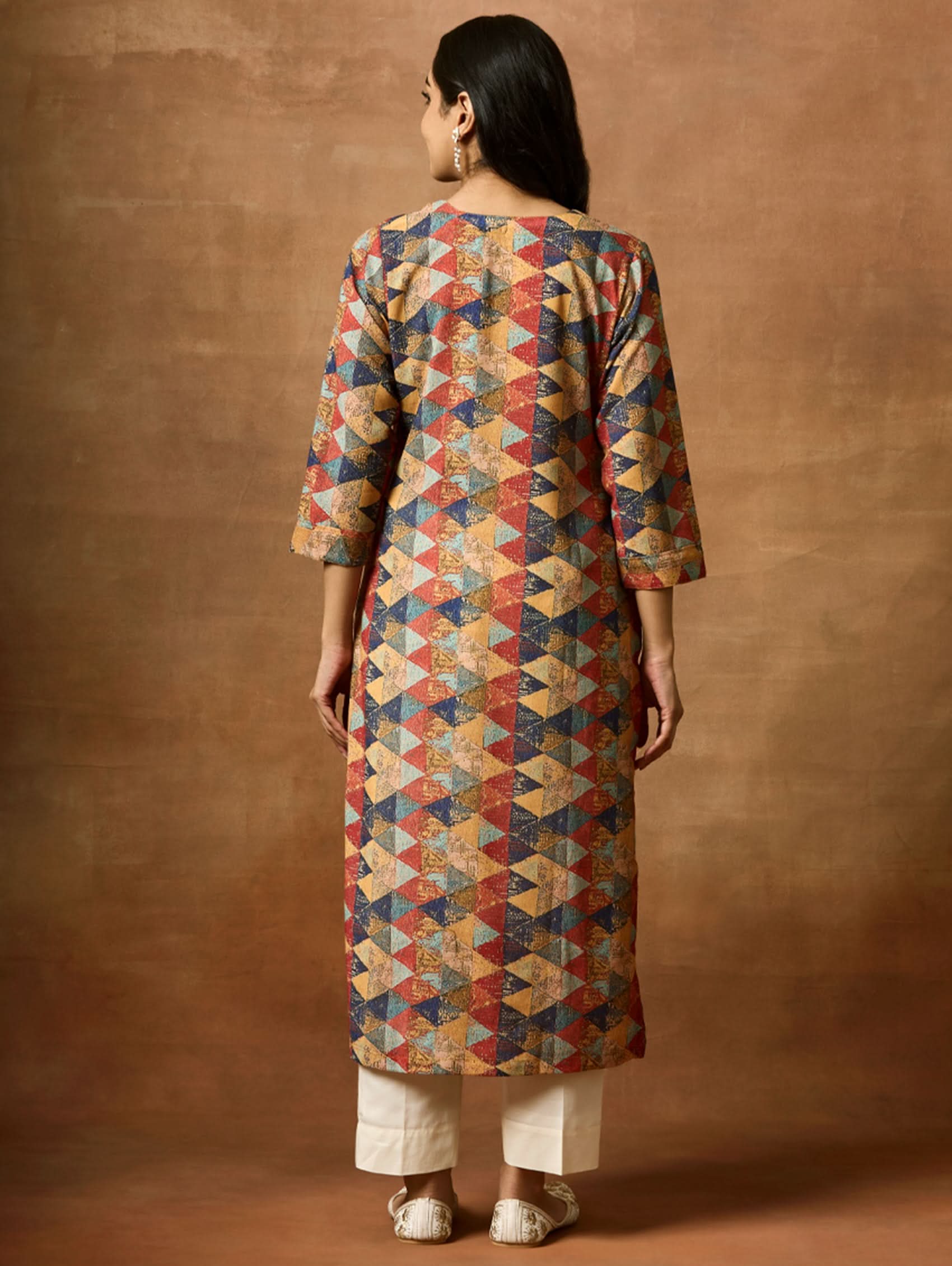 A woman plus size model wearing a multicolored geometric patterned kurta with Keyhole round neckline and three-fourth sleeves.