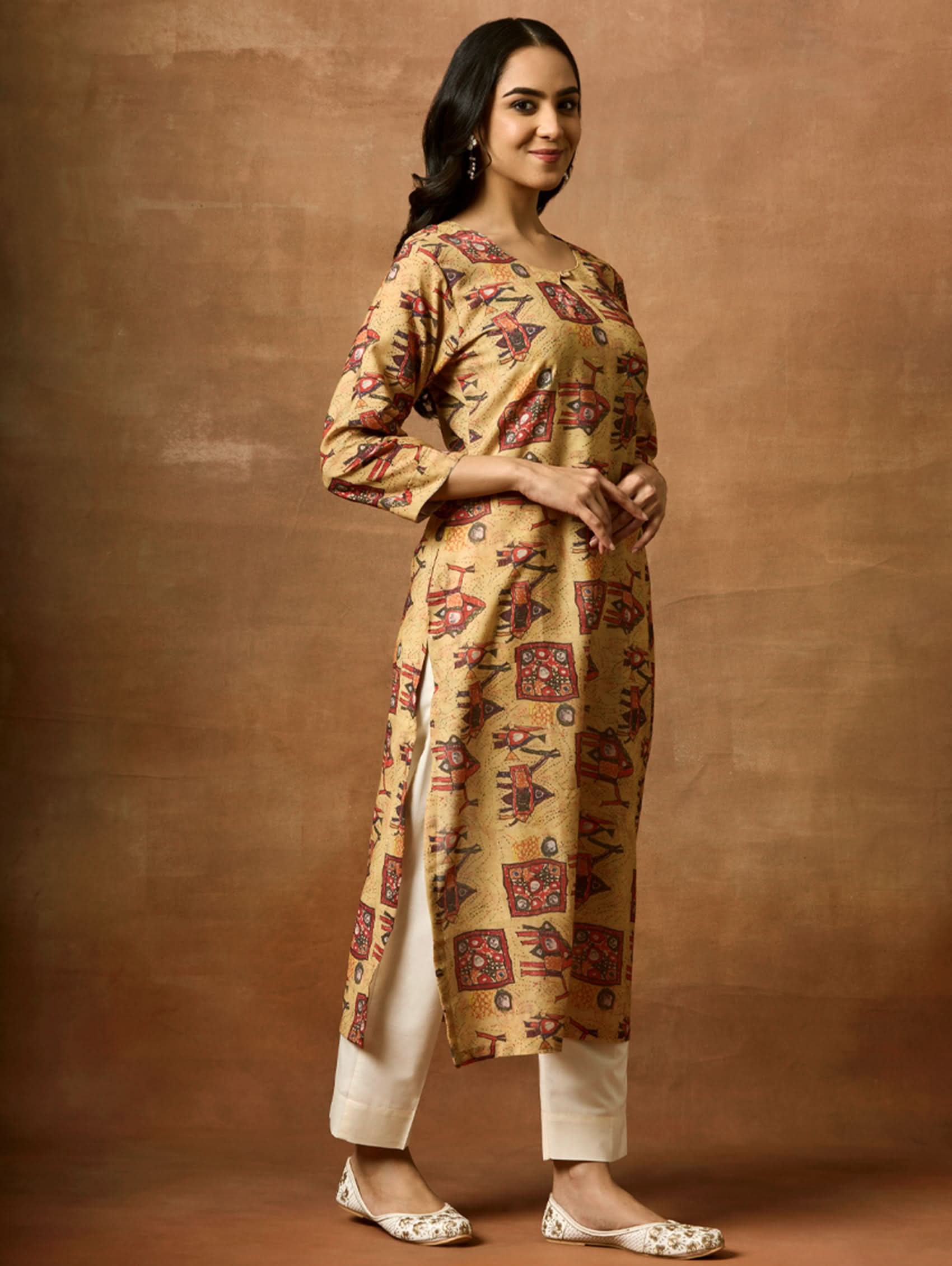 A woman plus size model wearing a beige and red printed viscose rayon kurta with round neckline, three-fourth sleeves, and side slits.