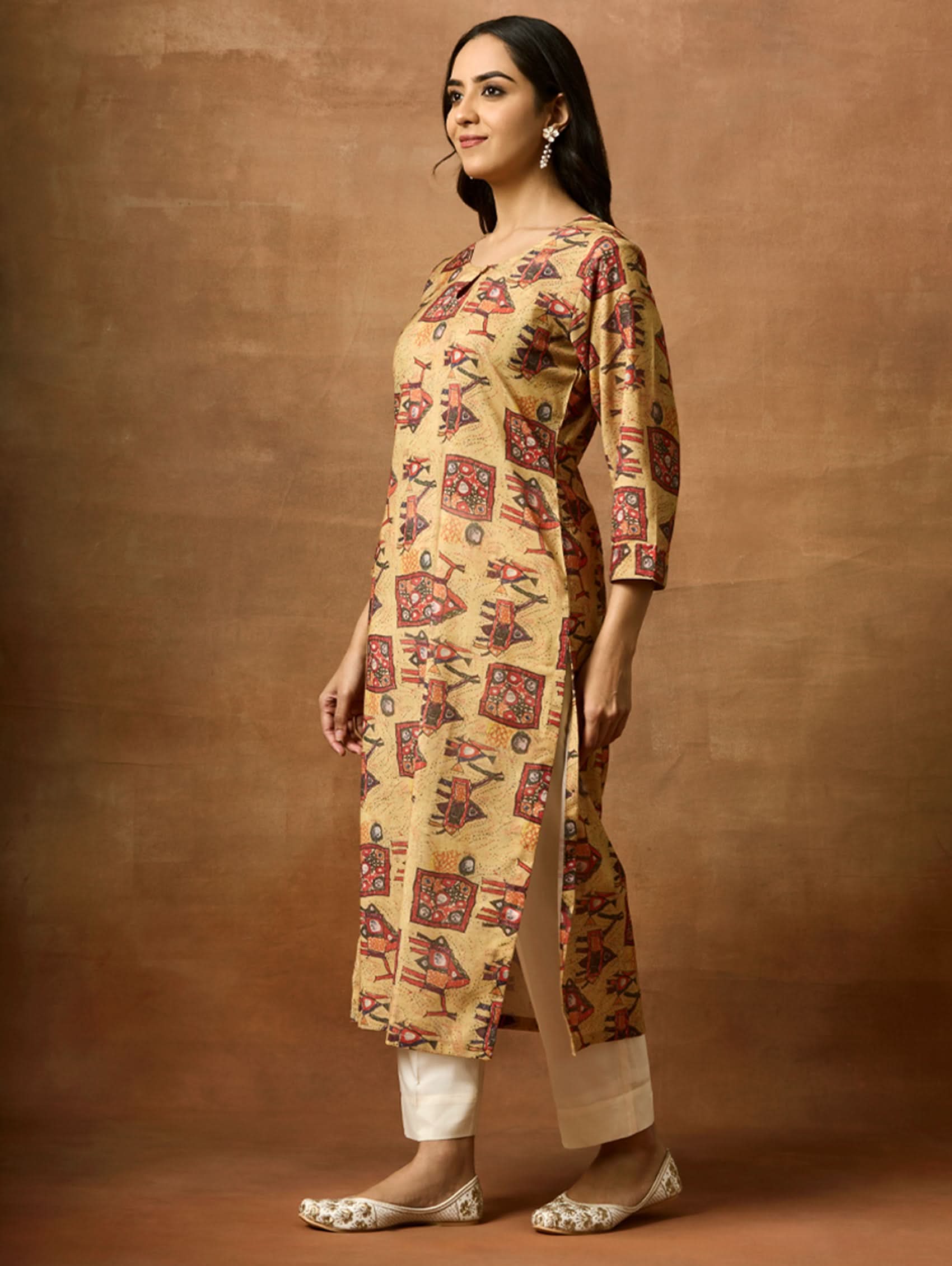 A woman plus size model wearing a beige and red printed viscose rayon kurta with round neckline, three-fourth sleeves, and side slits.