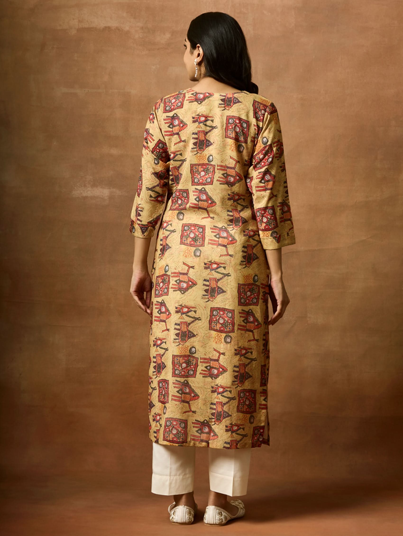 A woman plus size model wearing a beige and red printed viscose rayon kurta with round neckline, three-fourth sleeves, and side slits.