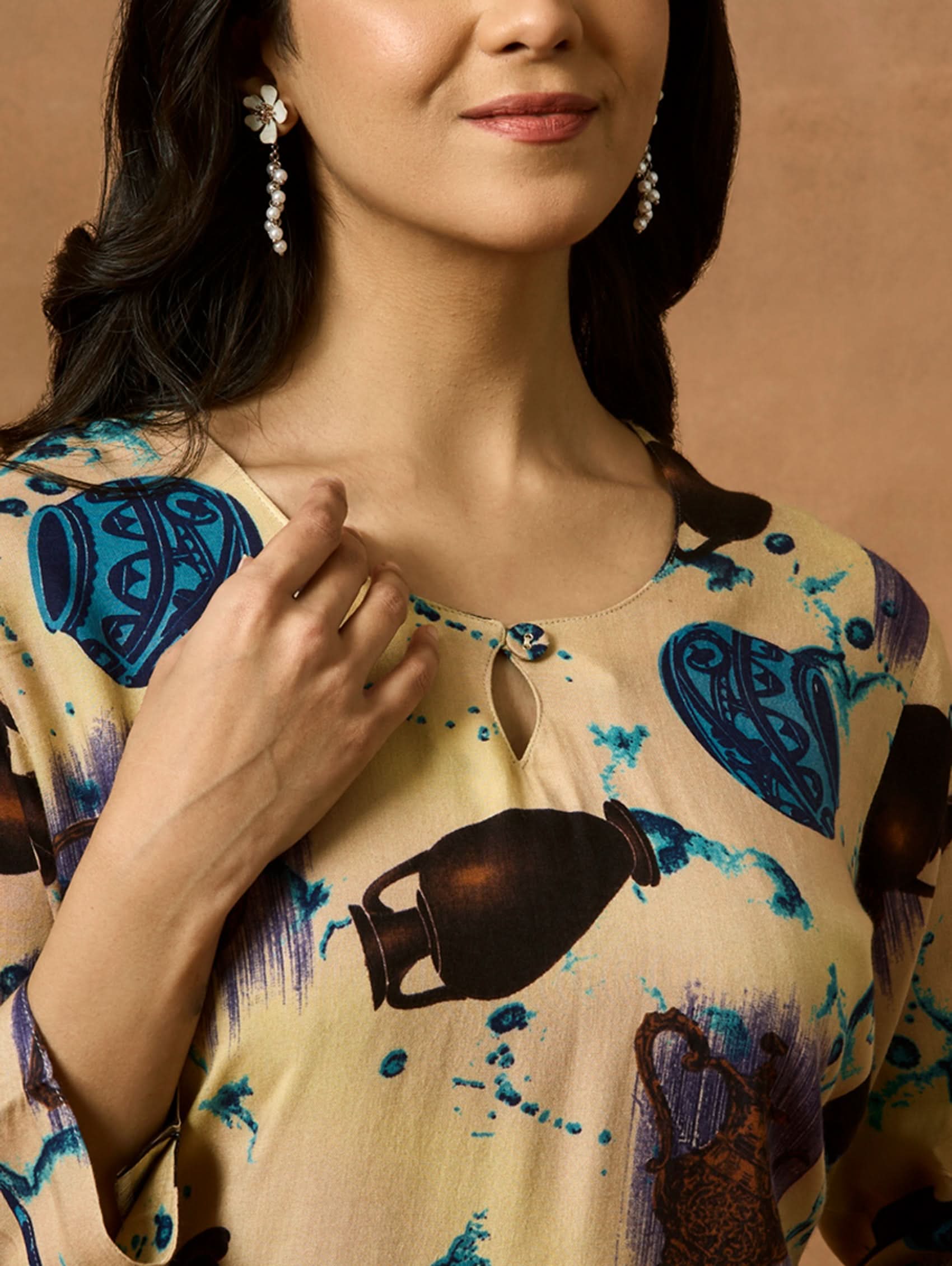 A woman plus size model wearing a beige kurta with animal prints, round neckline, and three-fourth sleeves.