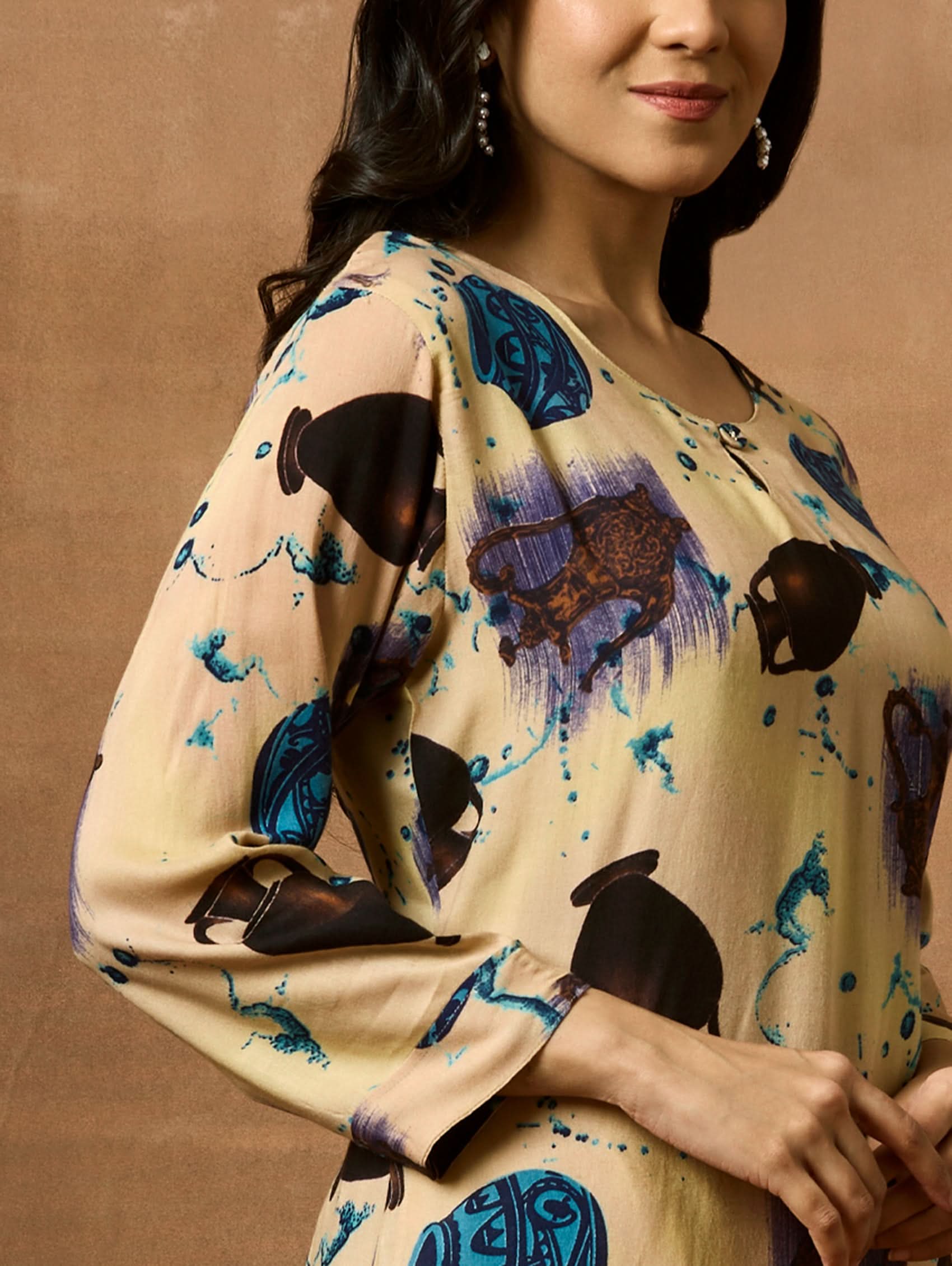 A woman plus size model wearing a beige kurta with animal prints, round neckline, and three-fourth sleeves.