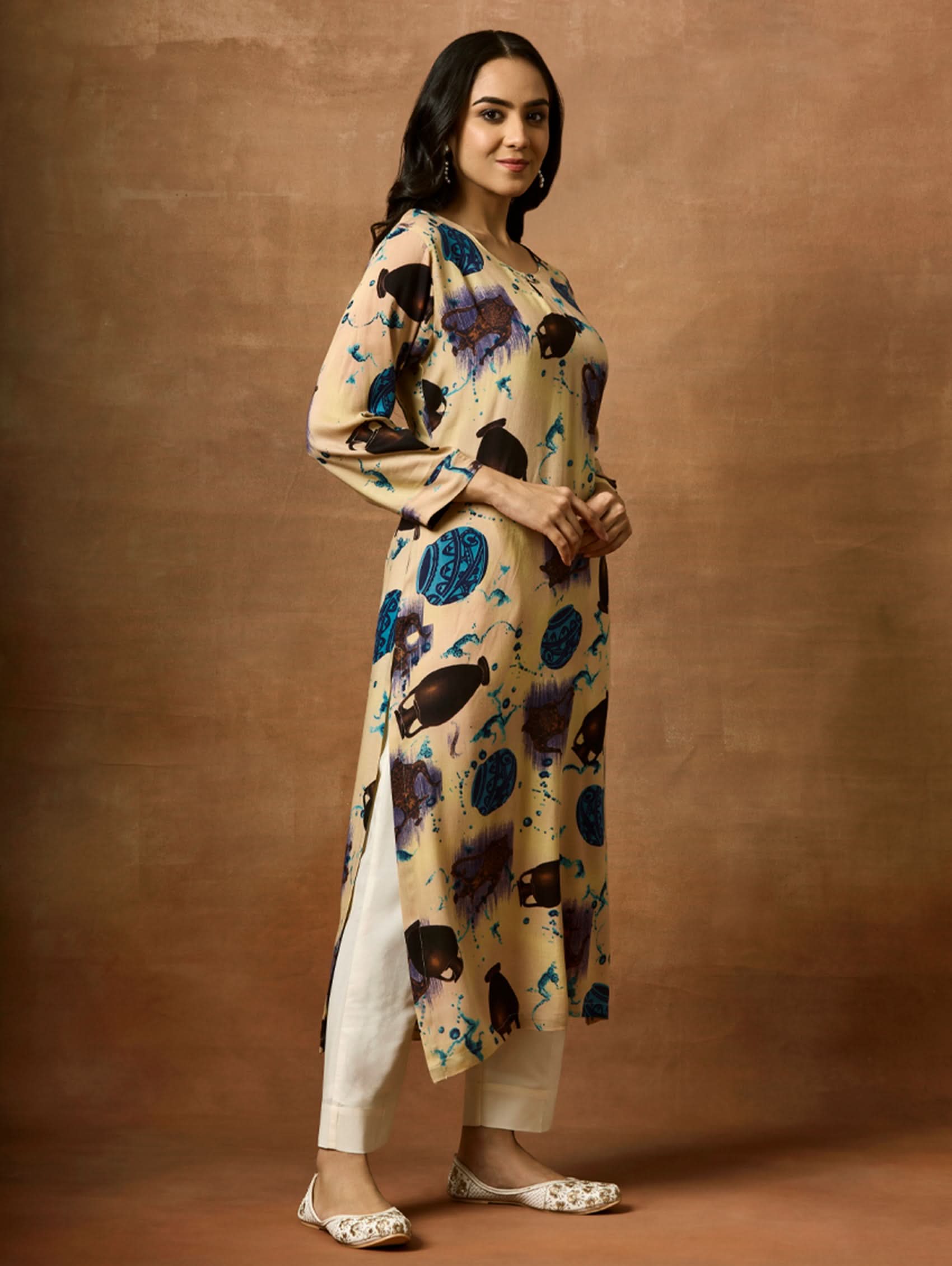 A woman plus size model wearing a beige kurta with animal prints, round neckline, and three-fourth sleeves.