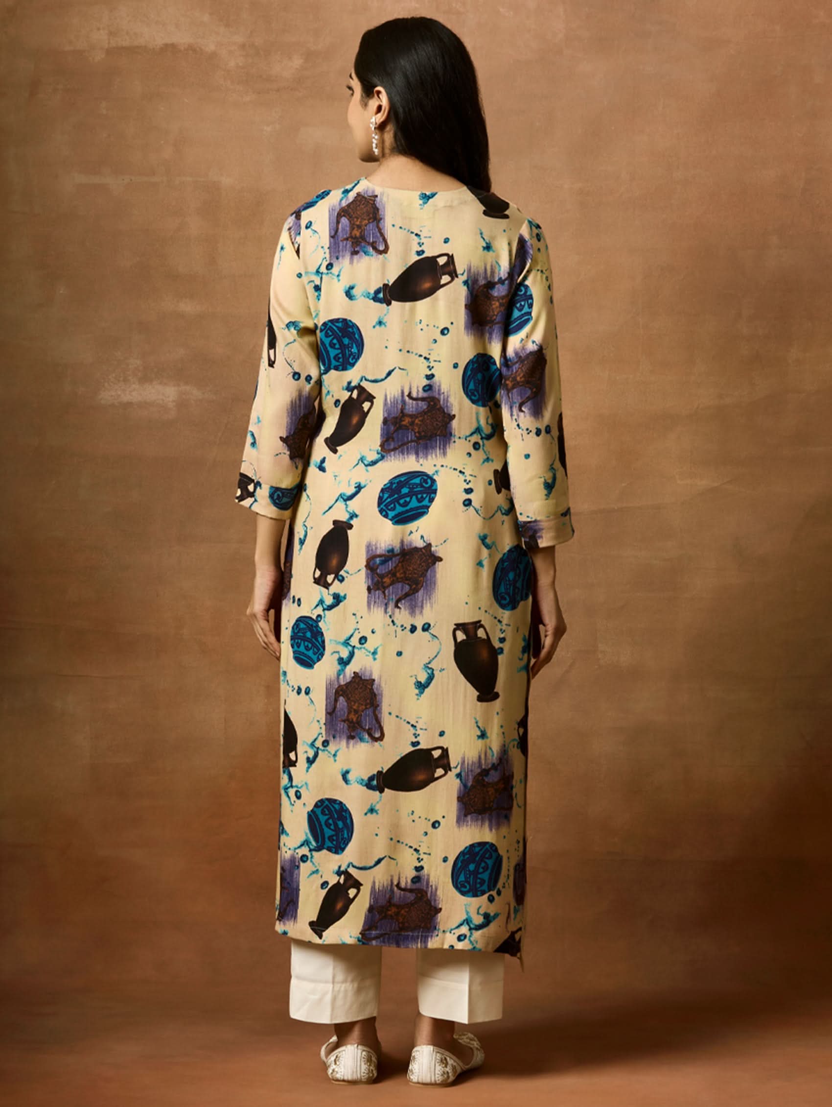 A woman plus size model wearing a beige kurta with animal prints, round neckline, and three-fourth sleeves.