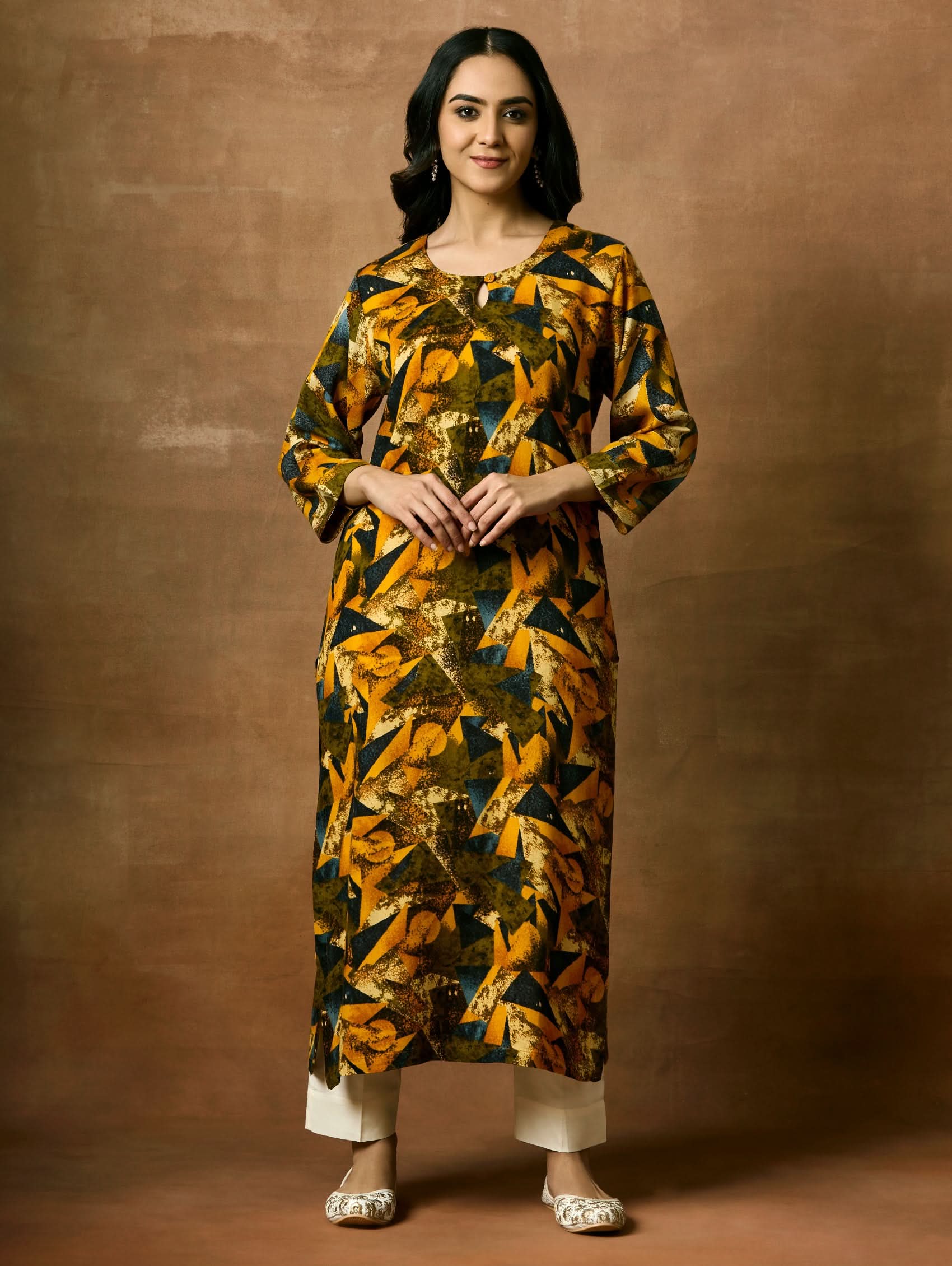 A woman plus size model wearing a printed viscose rayon kurta with a keyhole round neckline, three-fourth sleeves, and side slits.