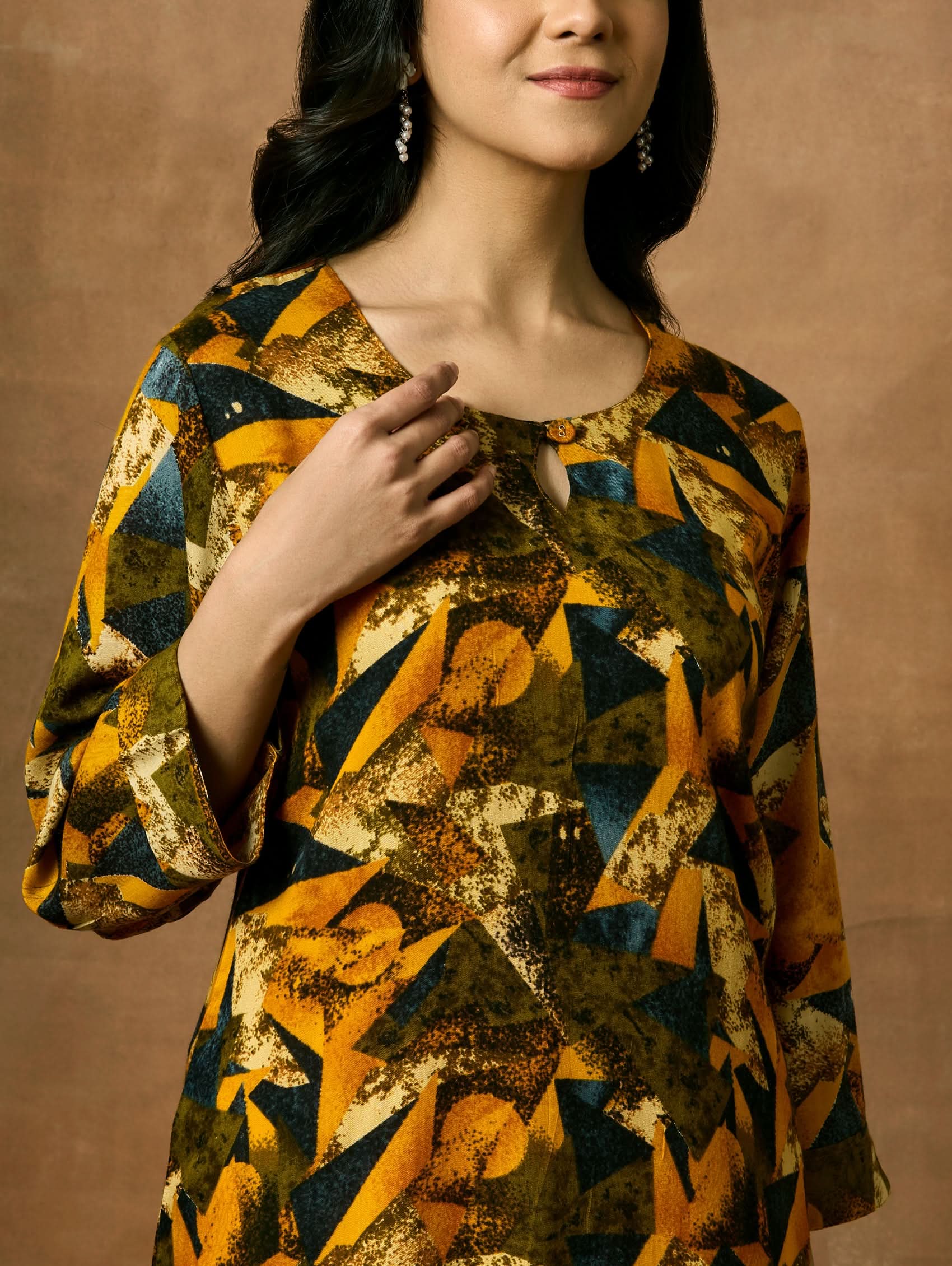 A woman plus size model wearing a printed viscose rayon kurta with a keyhole round neckline, three-fourth sleeves, and side slits.