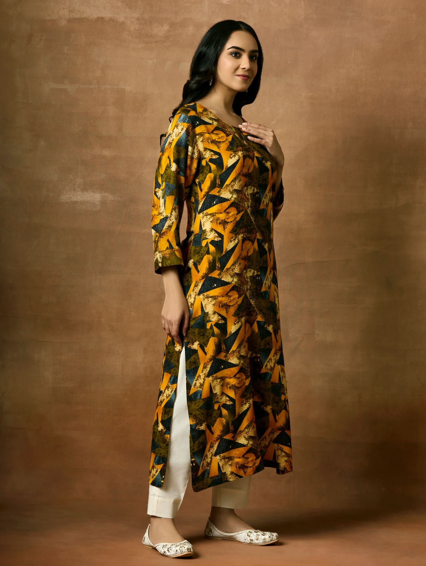 A woman plus size model wearing a printed viscose rayon kurta with a keyhole round neckline, three-fourth sleeves, and side slits.