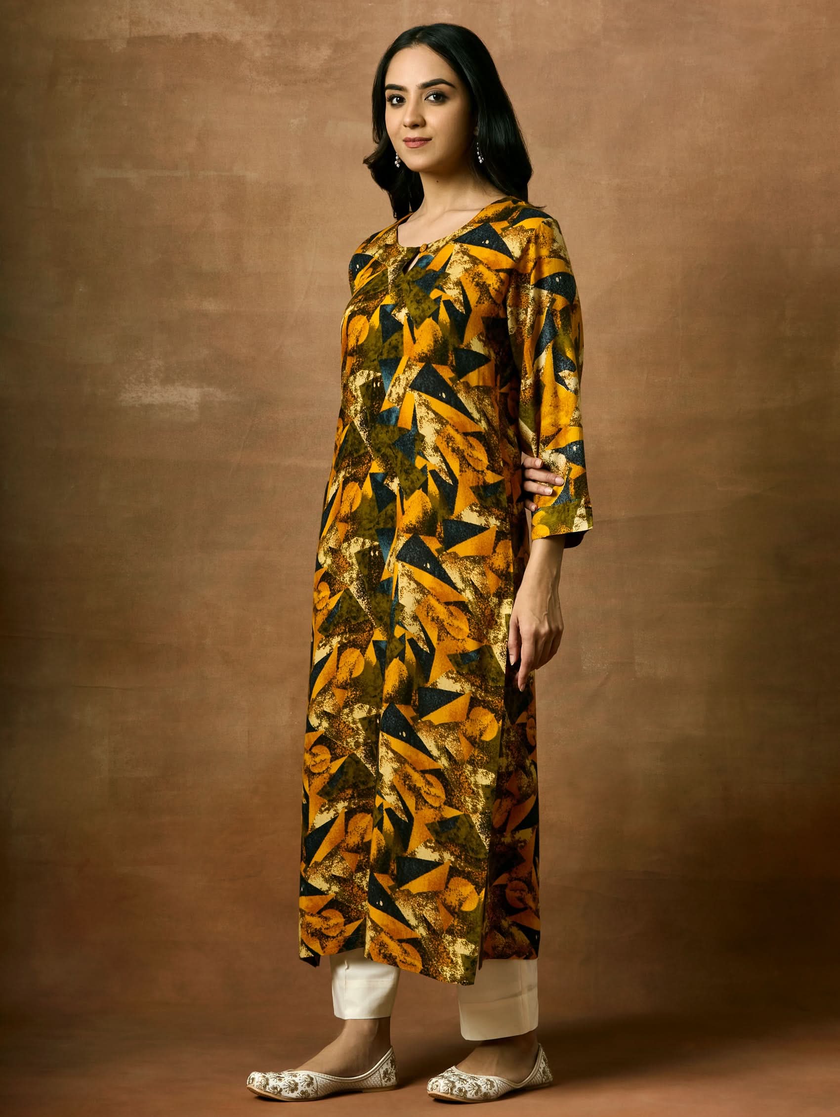 A woman plus size model wearing a printed viscose rayon kurta with a keyhole round neckline, three-fourth sleeves, and side slits.