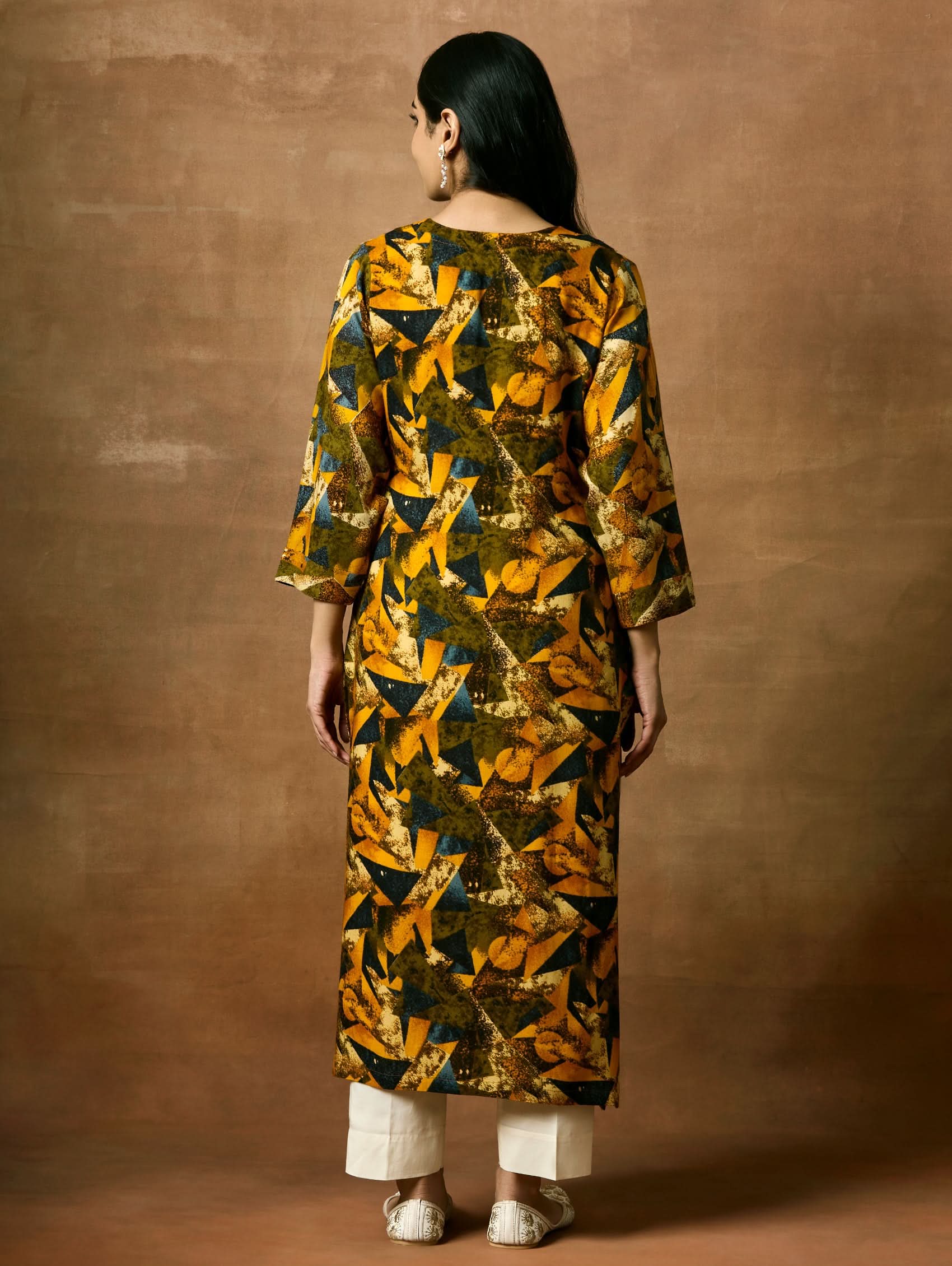 A woman plus size model wearing a printed viscose rayon kurta with a keyhole round neckline, three-fourth sleeves, and side slits.