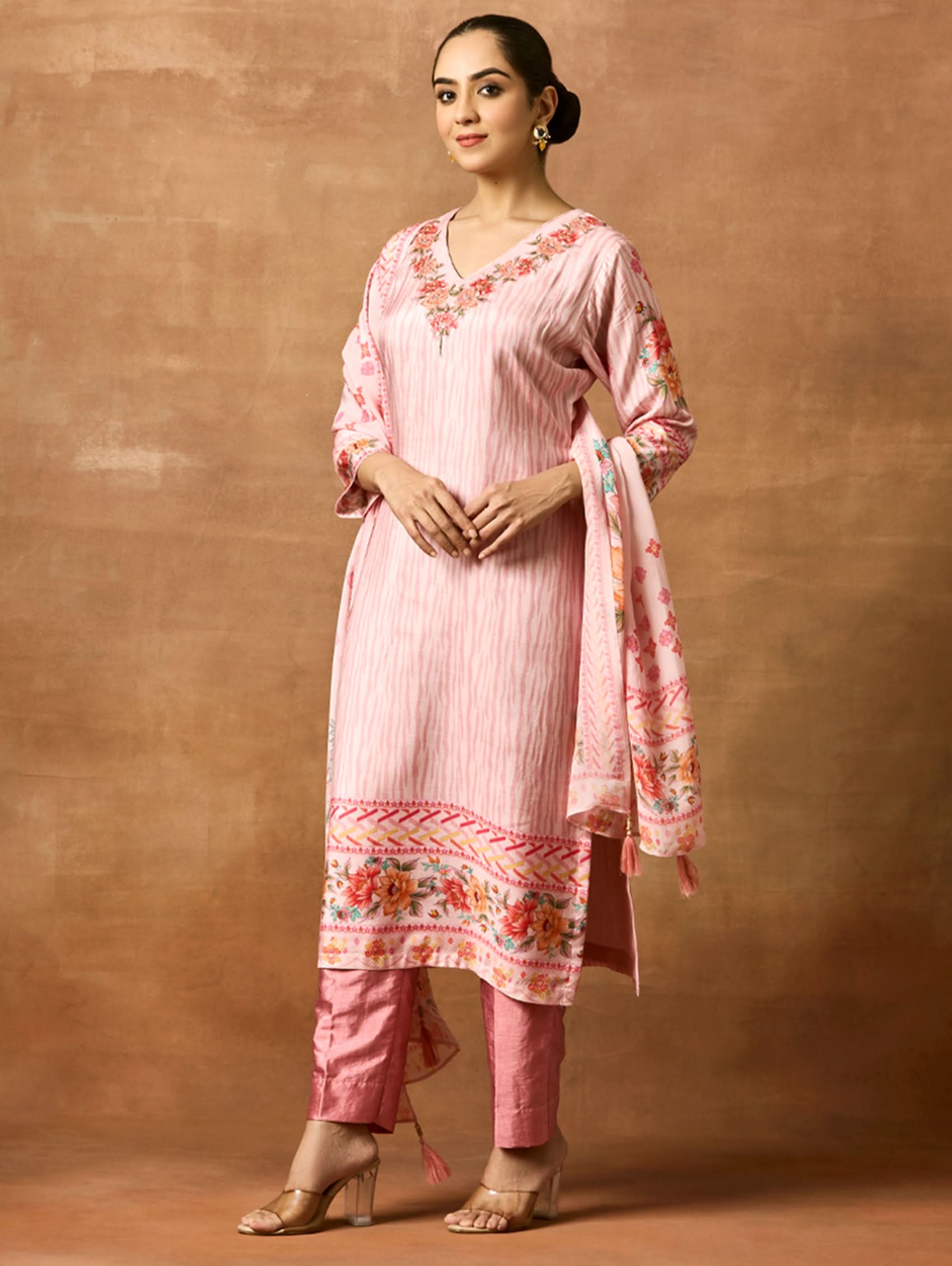A woman modeling a pink and red digitally printed pure viscose muslin silk suit set with a kurta, pants, and a dupatta.