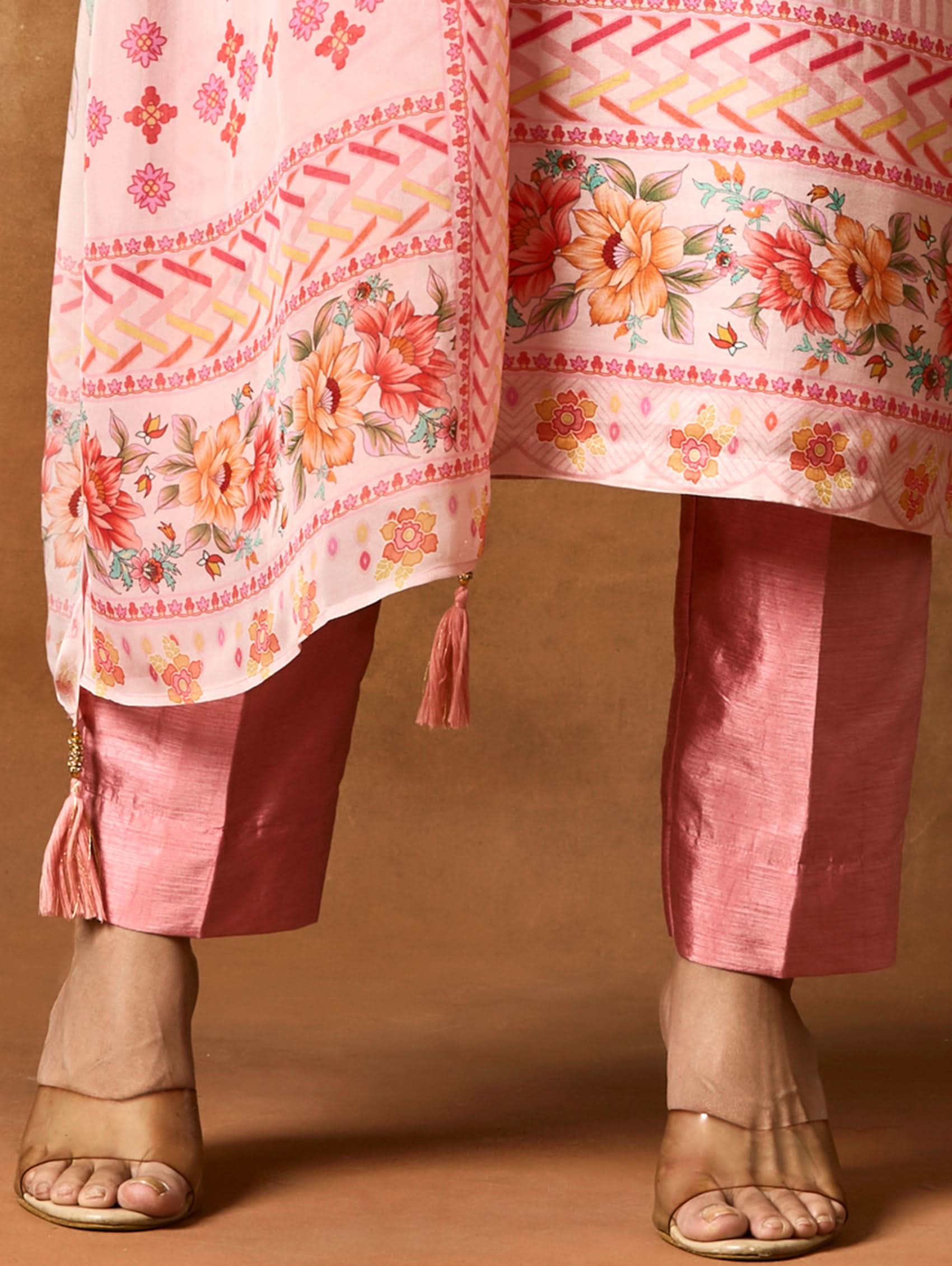 A woman modeling a pink and red digitally printed pure viscose muslin silk suit set with a kurta, pants, and a dupatta.