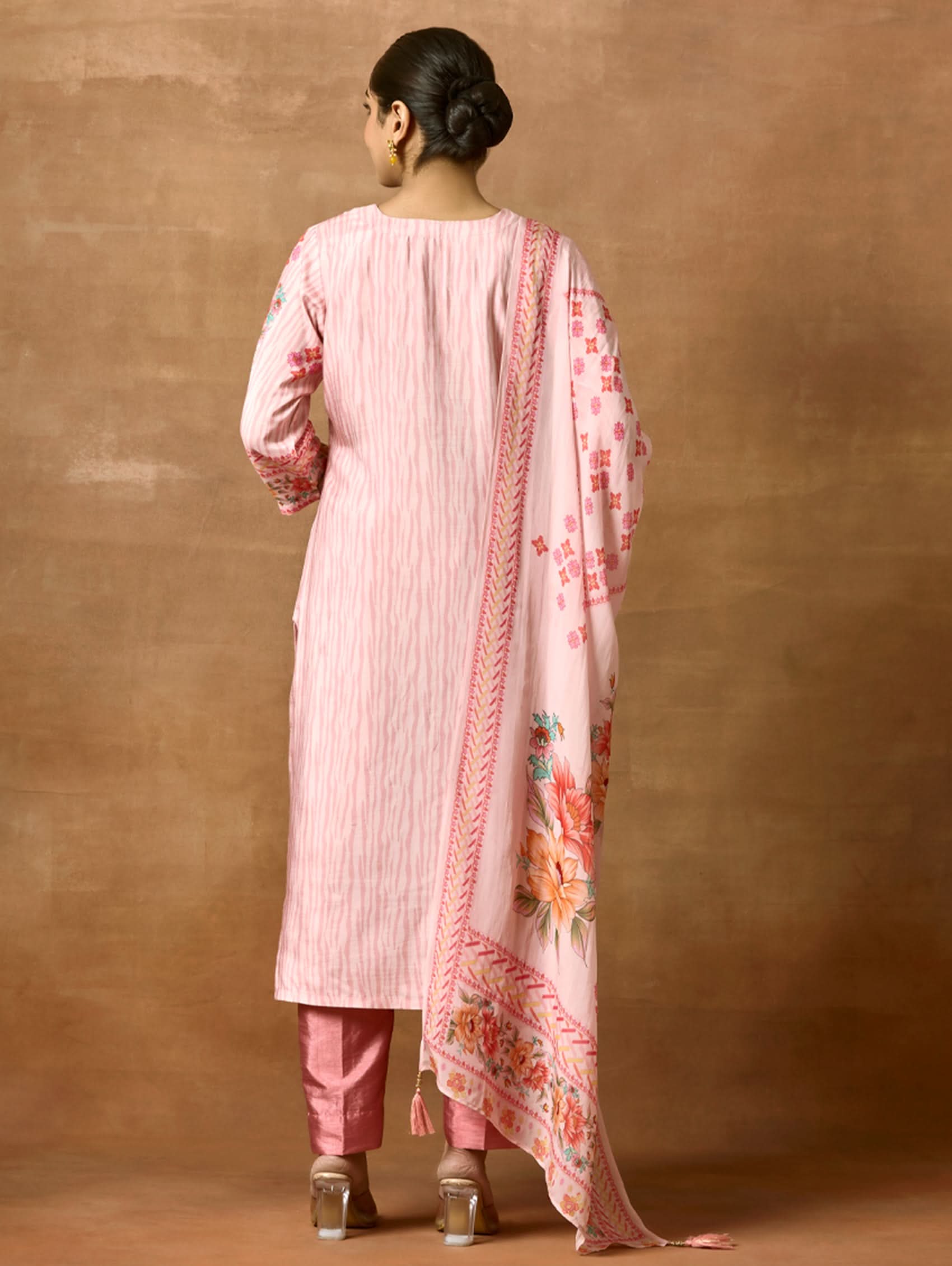 A woman modeling a pink and red digitally printed pure viscose muslin silk suit set with a kurta, pants, and a dupatta.