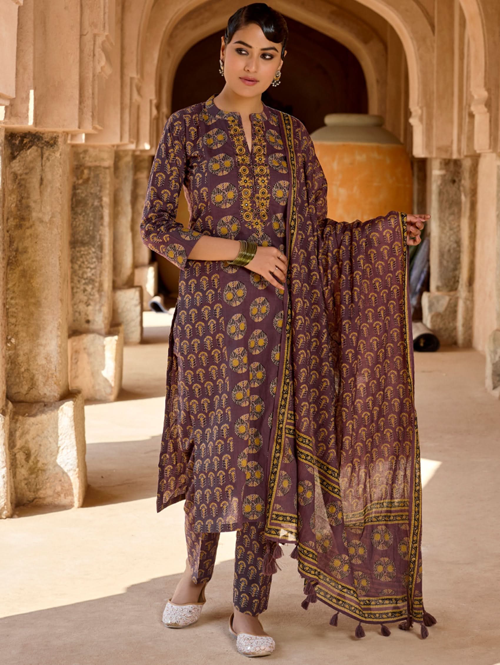 A woman wearing a purple and multicolored embroidered pure cotton suit set with a kurta, pants, and a dupatta.