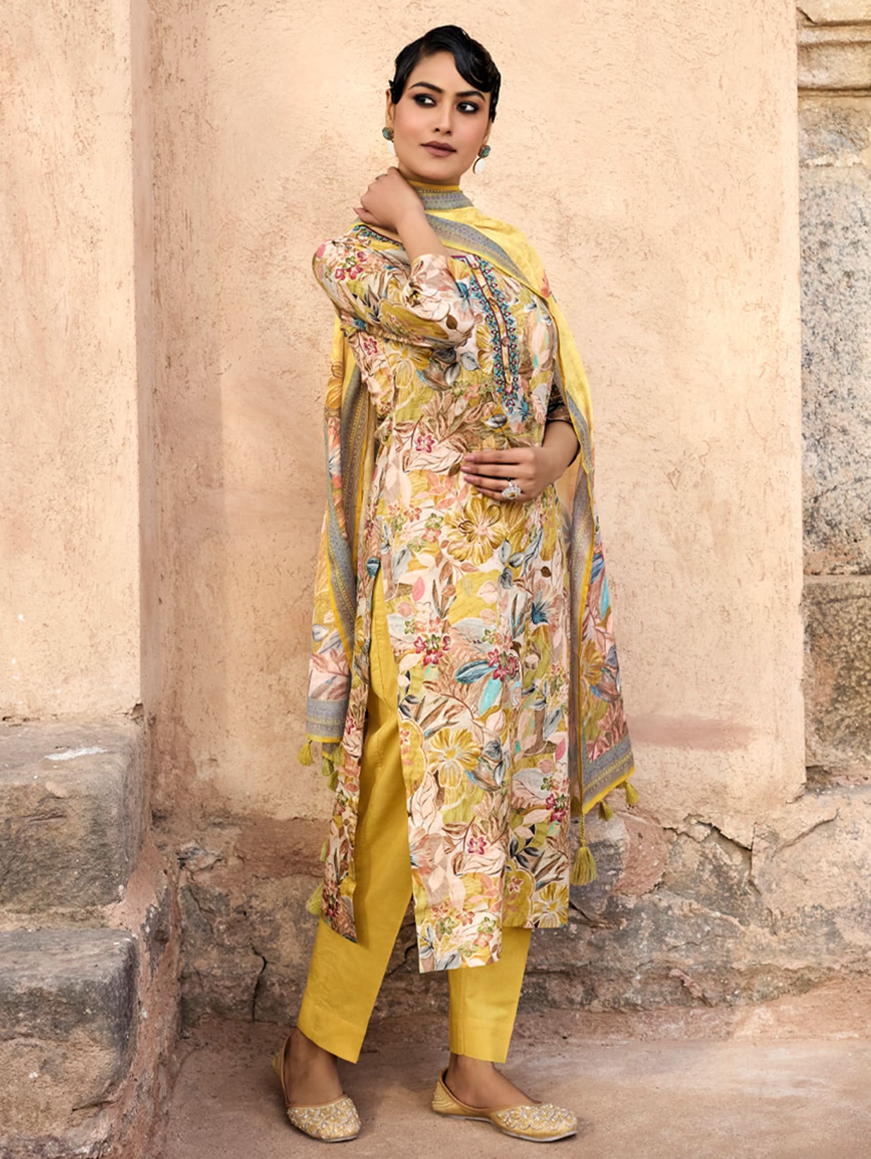 A woman wearing a yellow and multicolor embroidered pure malai cotton suit set with a kurta, pants, and a dupatta.