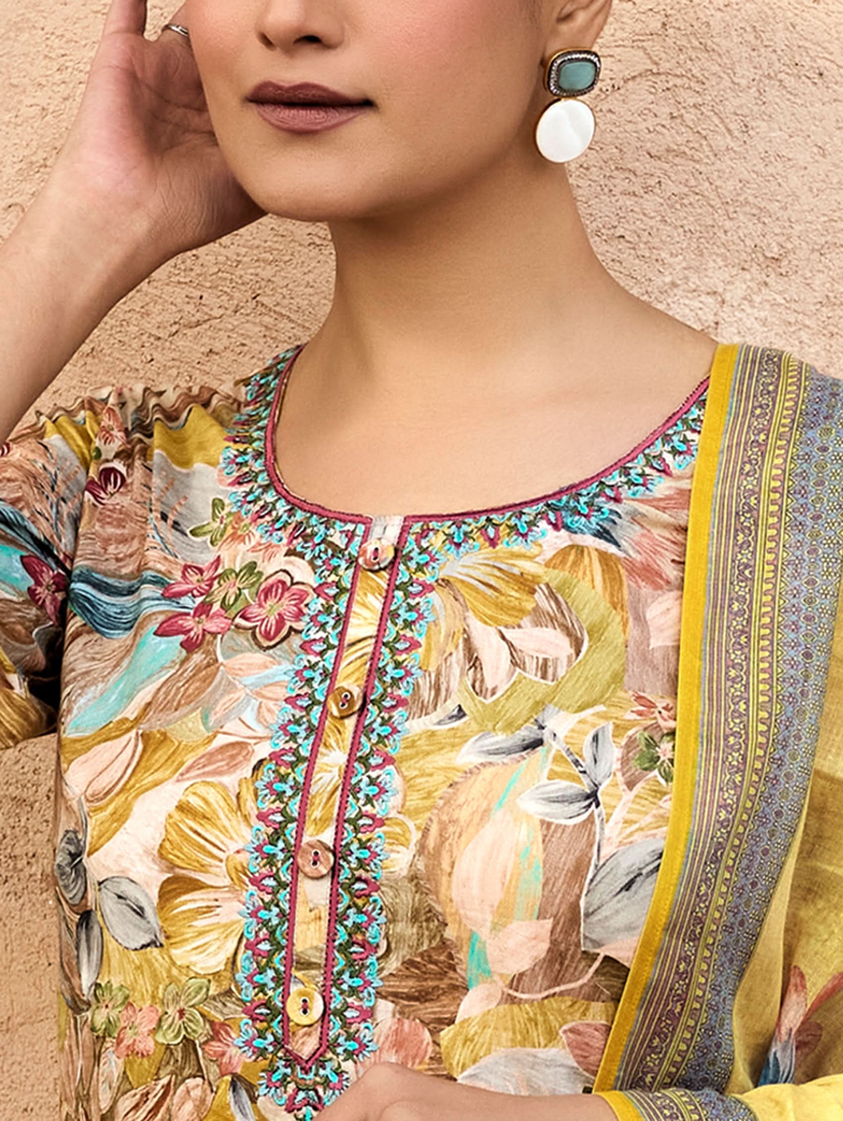 A woman wearing a yellow and multicolor embroidered pure malai cotton suit set with a kurta, pants, and a dupatta.
