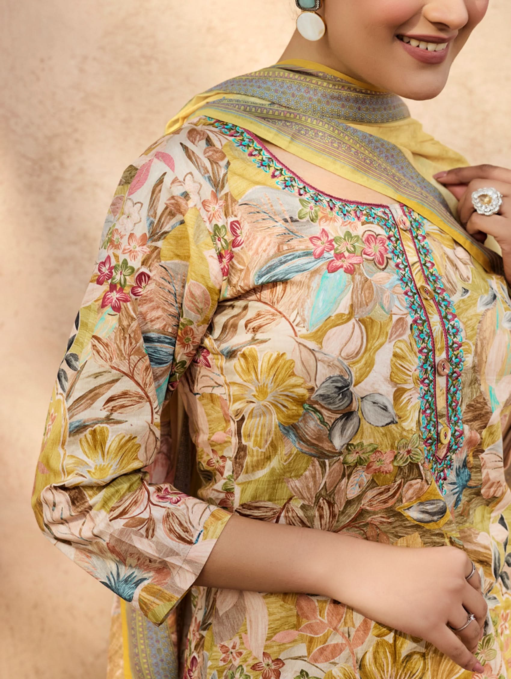 A woman wearing a yellow and multicolor embroidered pure malai cotton suit set with a kurta, pants, and a dupatta.