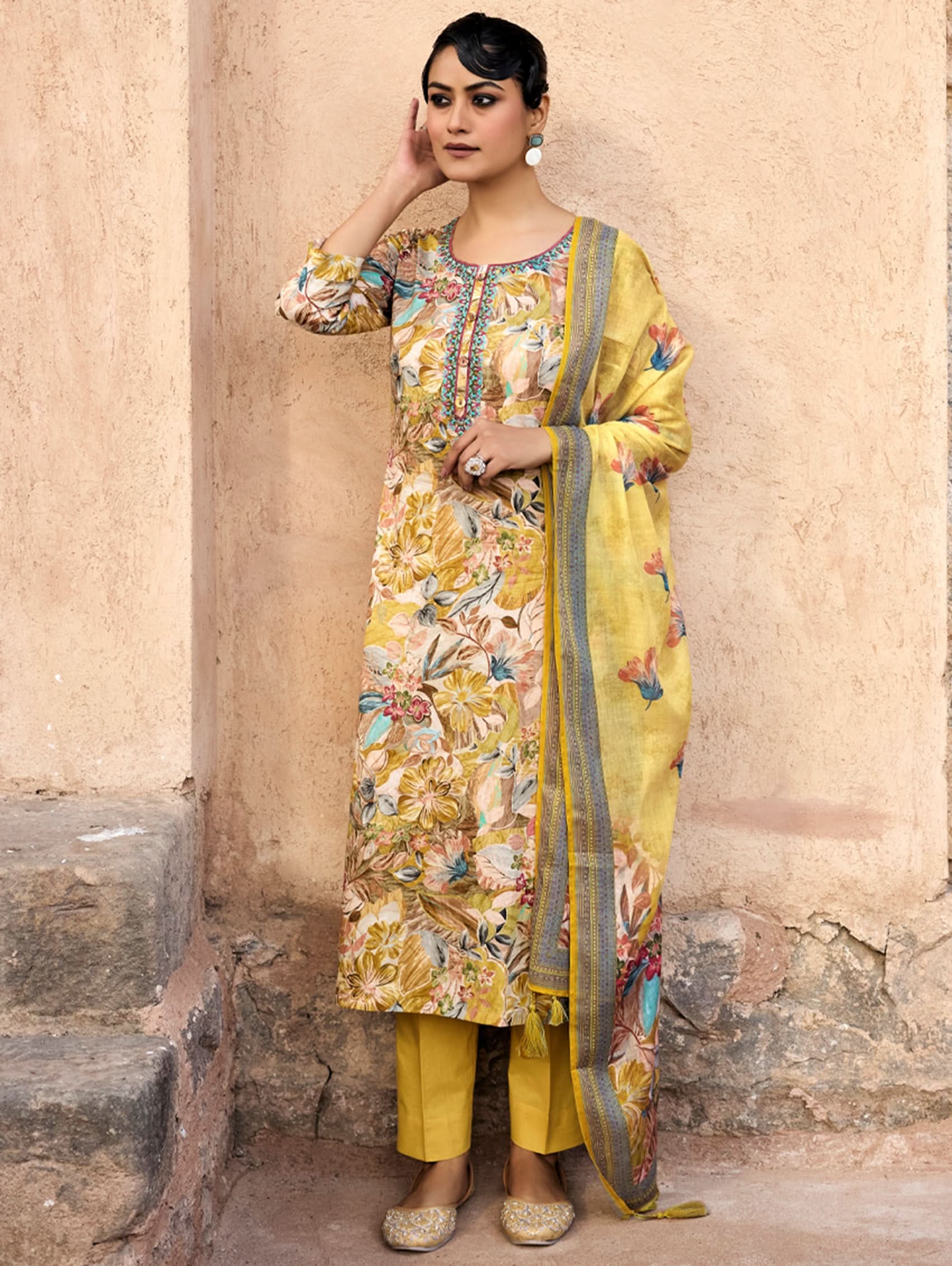 A woman wearing a yellow and multicolor embroidered pure malai cotton suit set with a kurta, pants, and a dupatta.