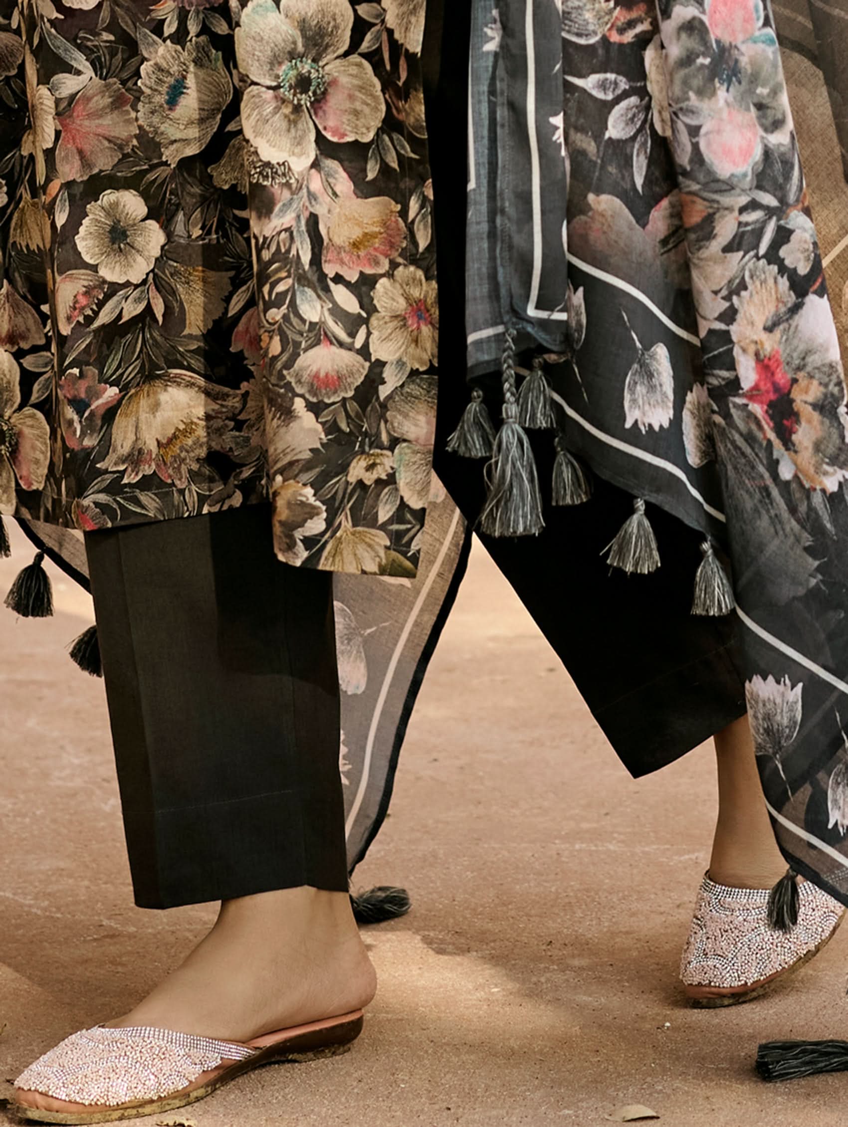 Floral embroidered kurta hem with black leggings and sheer dupatta tassels, close-up