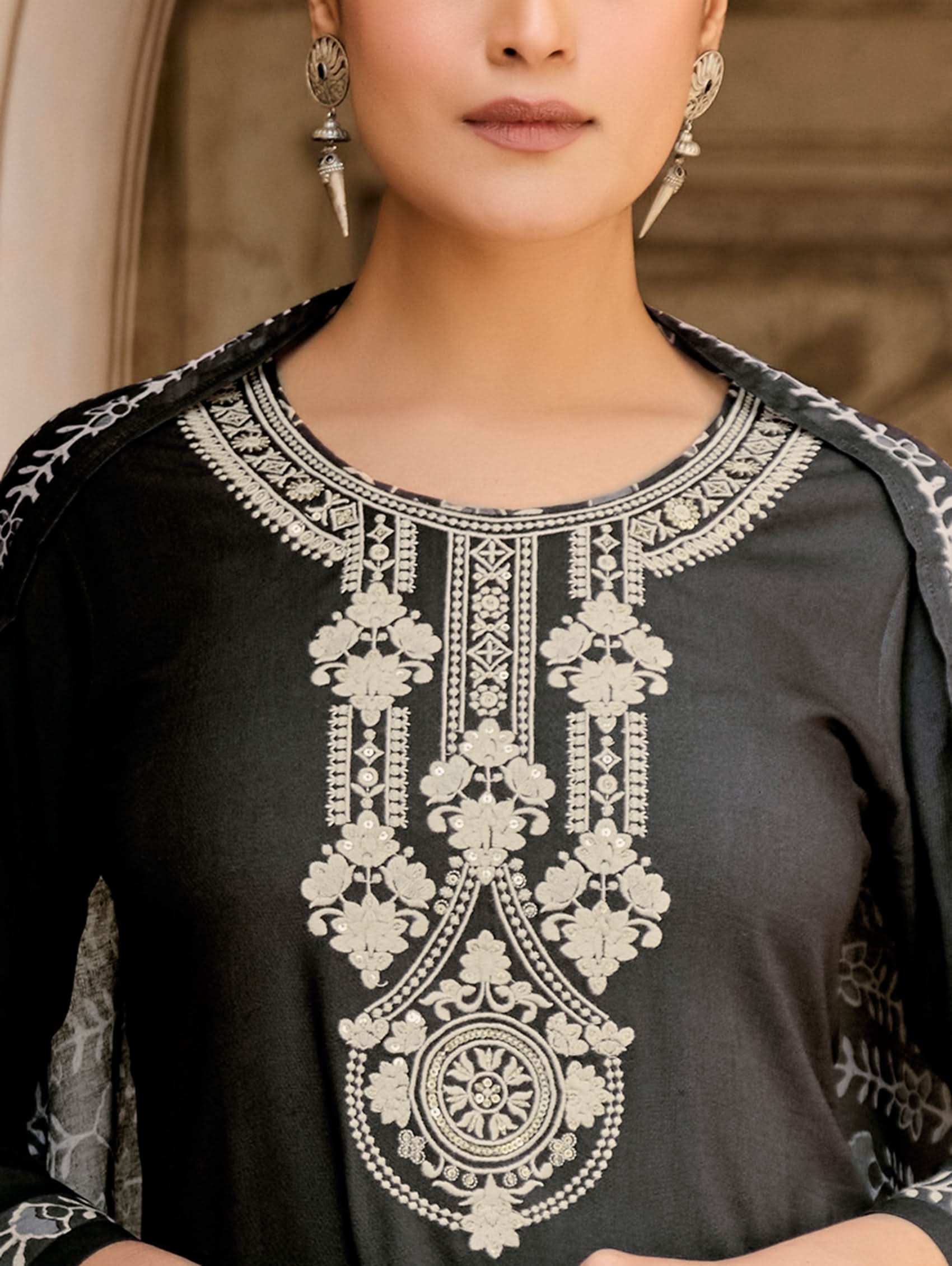 Black garment with intricate white embroidery on the neckline and sleeves.