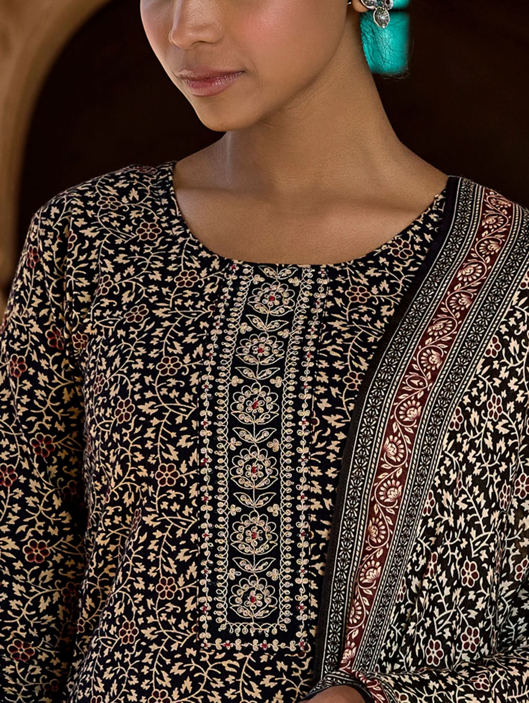 Close-up of a person wearing a patterned garment with intricate designs.