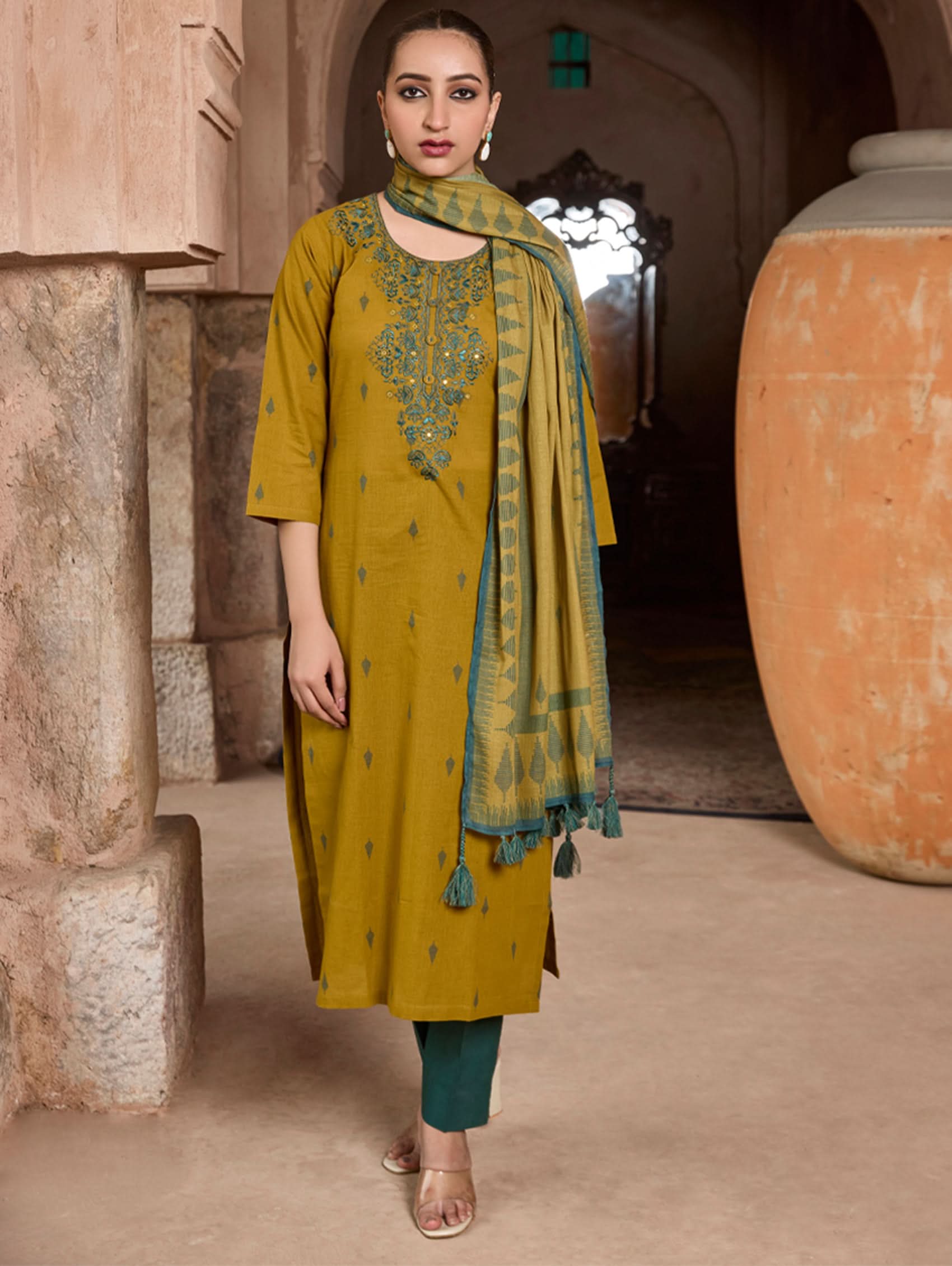 A woman modeling a yellow and green Jamdani Pure Cotton suit set with embroidery on the kurta, paired with straight pants and a matching dupatta.