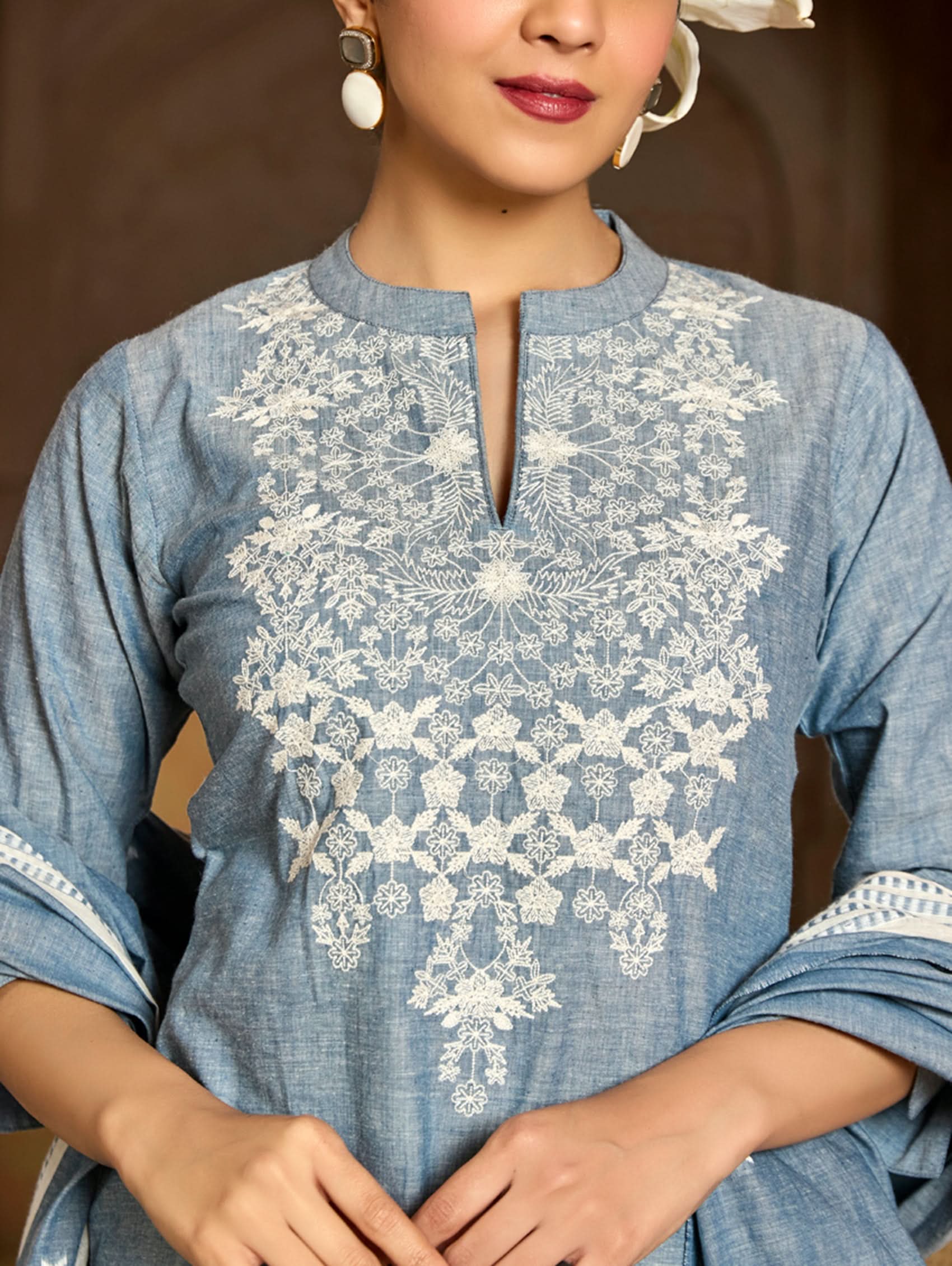 Blue kurta with white lace embroidery worn by a person.