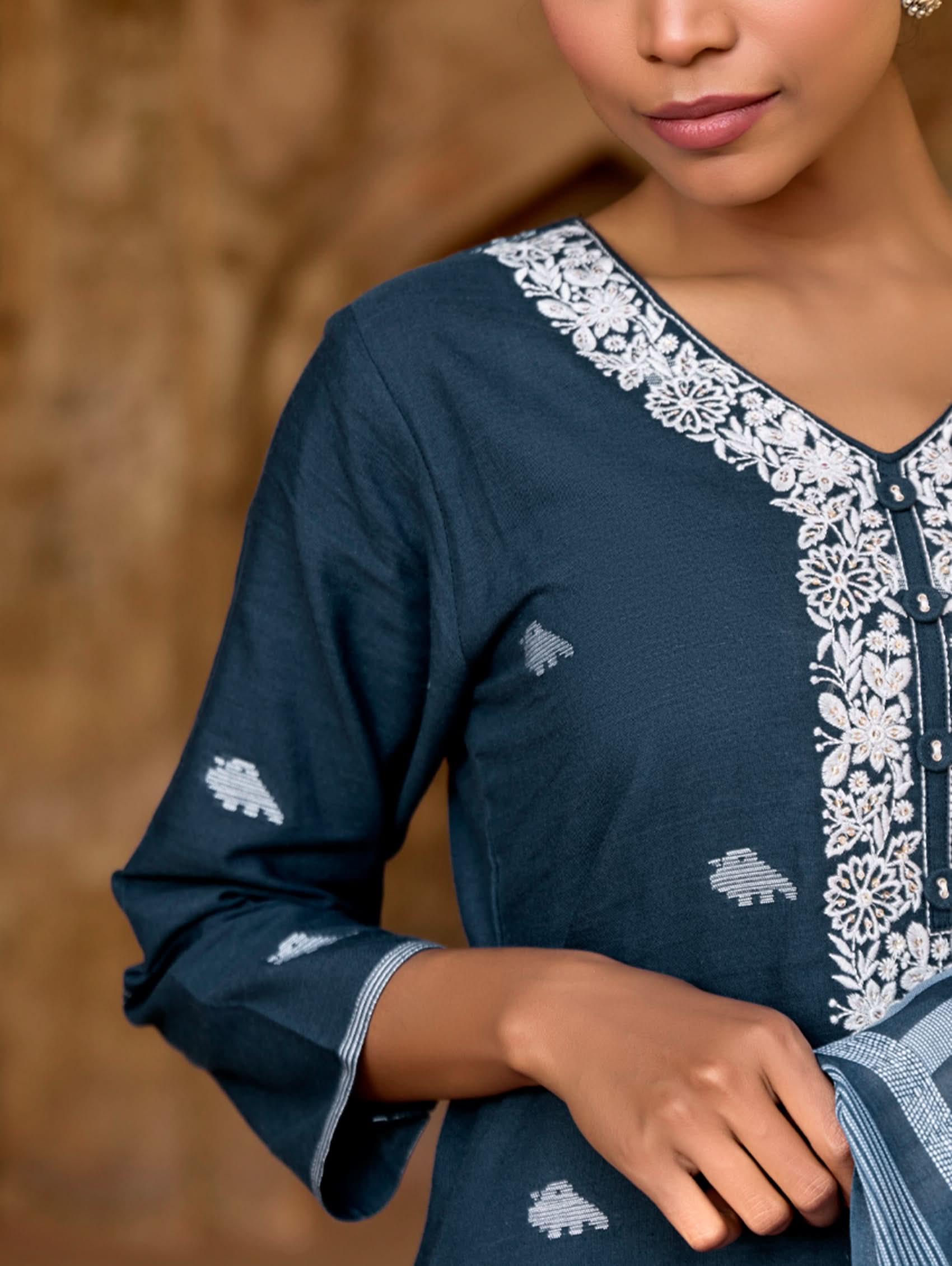 Dark blue dress with white embroidery and floral patterns.