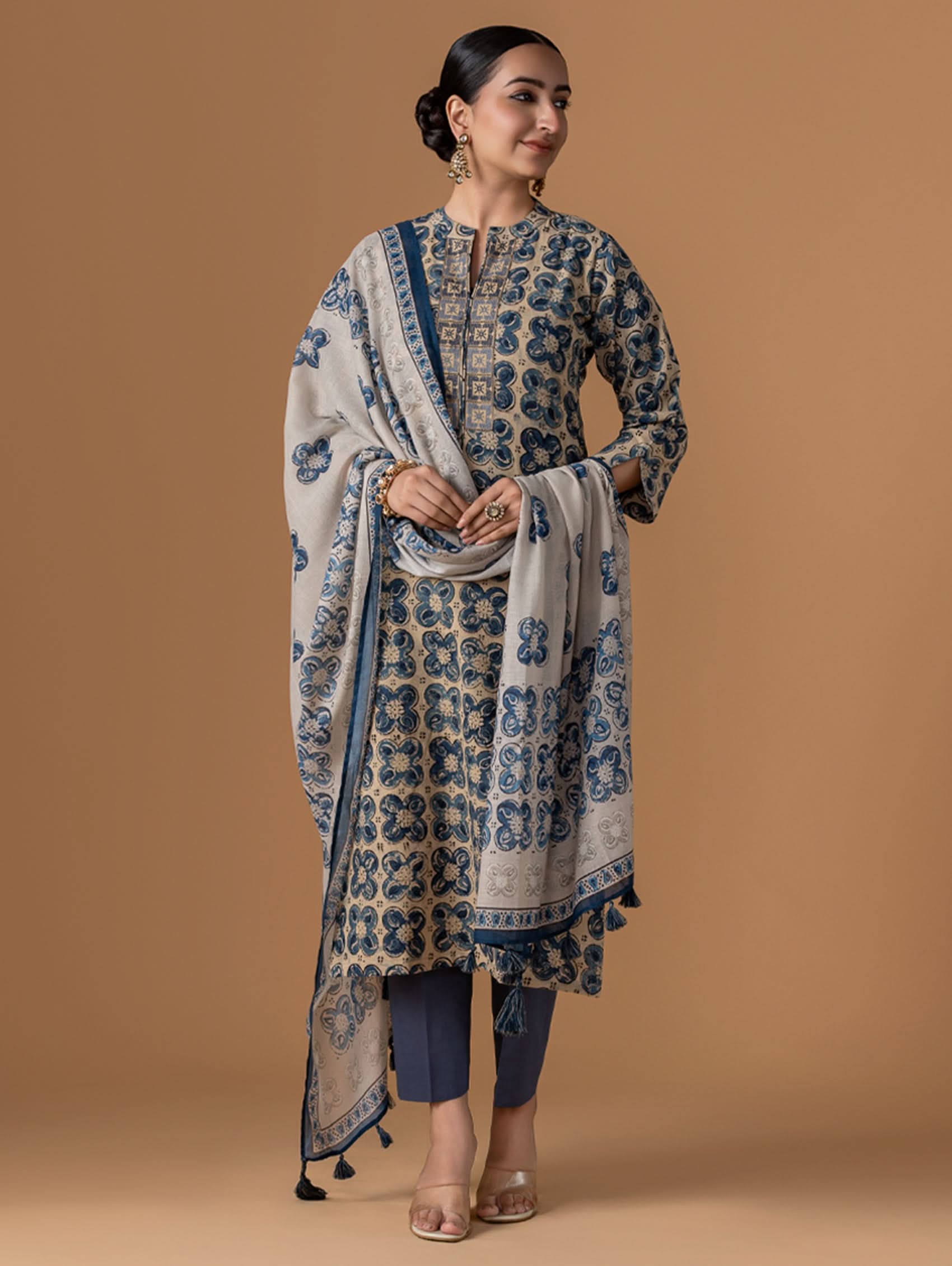 A woman modeling a blue and white kalamkari pure cotton suit set with a kurta, pants, and a dupatta.