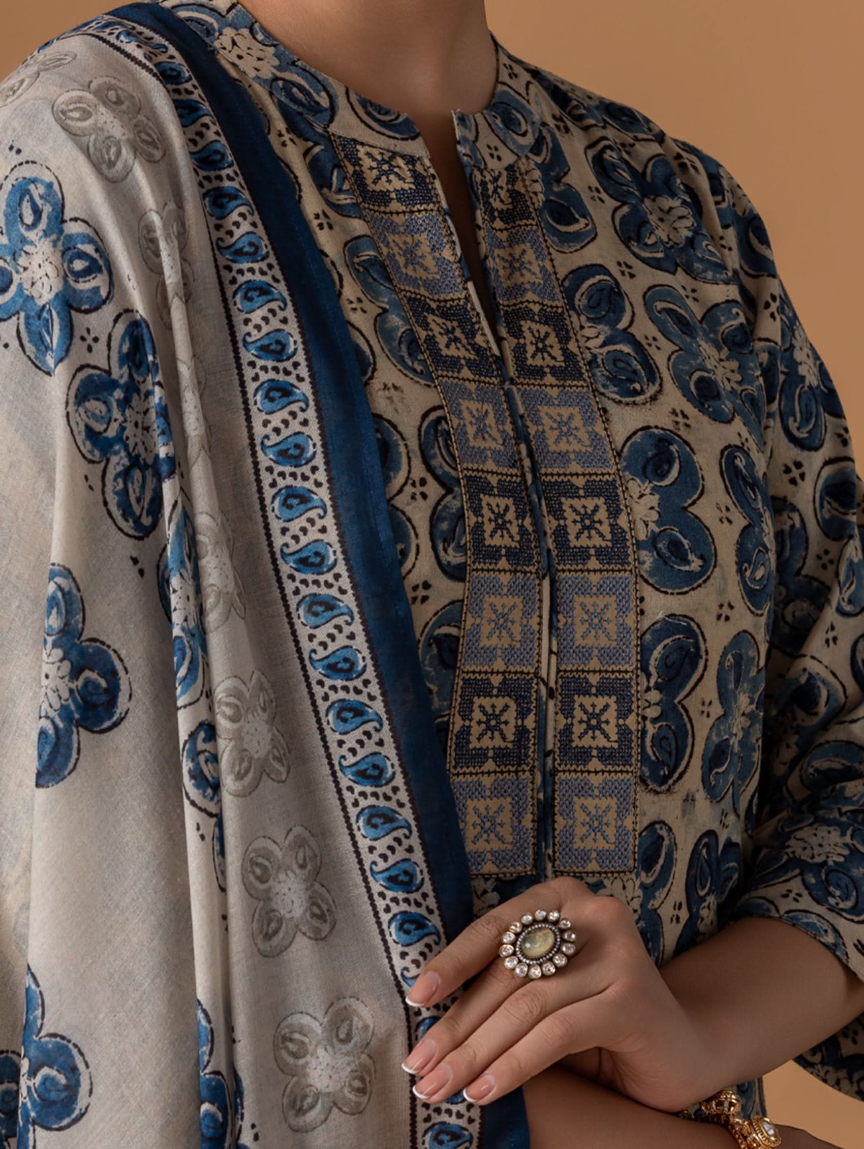 Person wearing a patterned garment with blue and beige design.