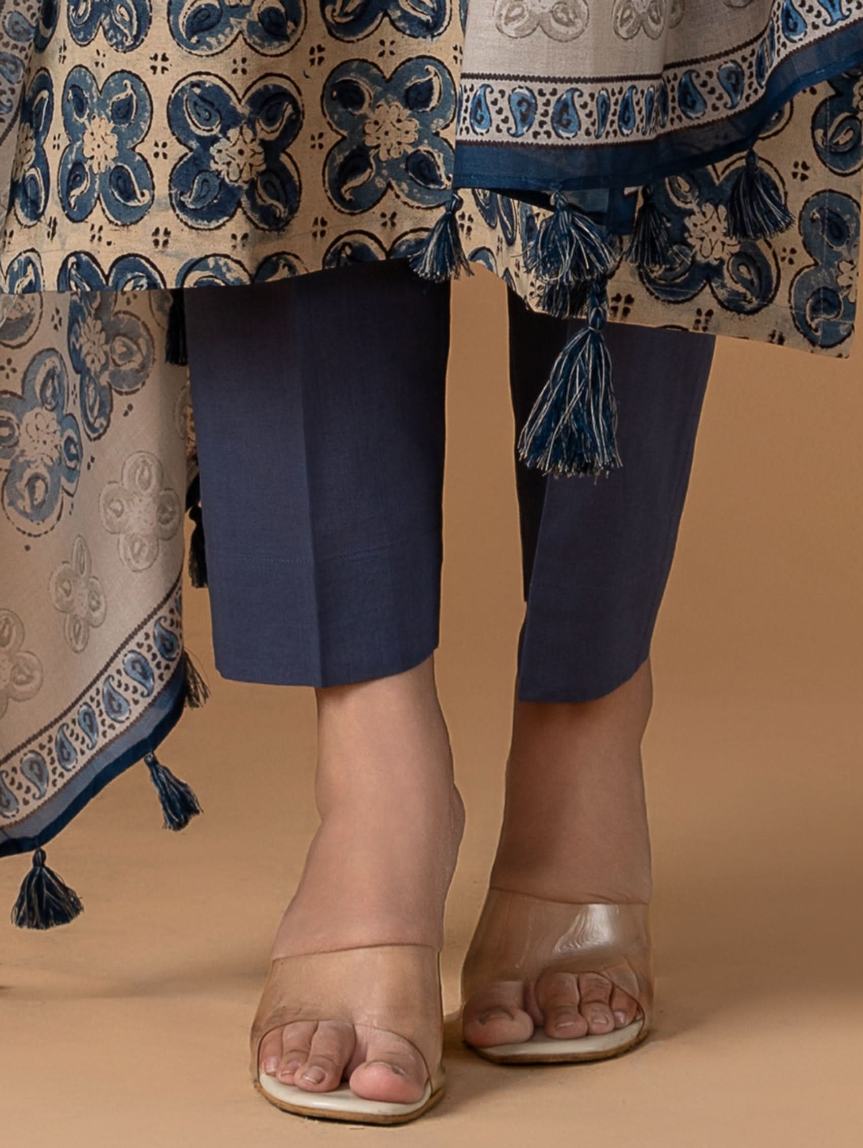 Navy blue pants with patterned shawl on a neutral background