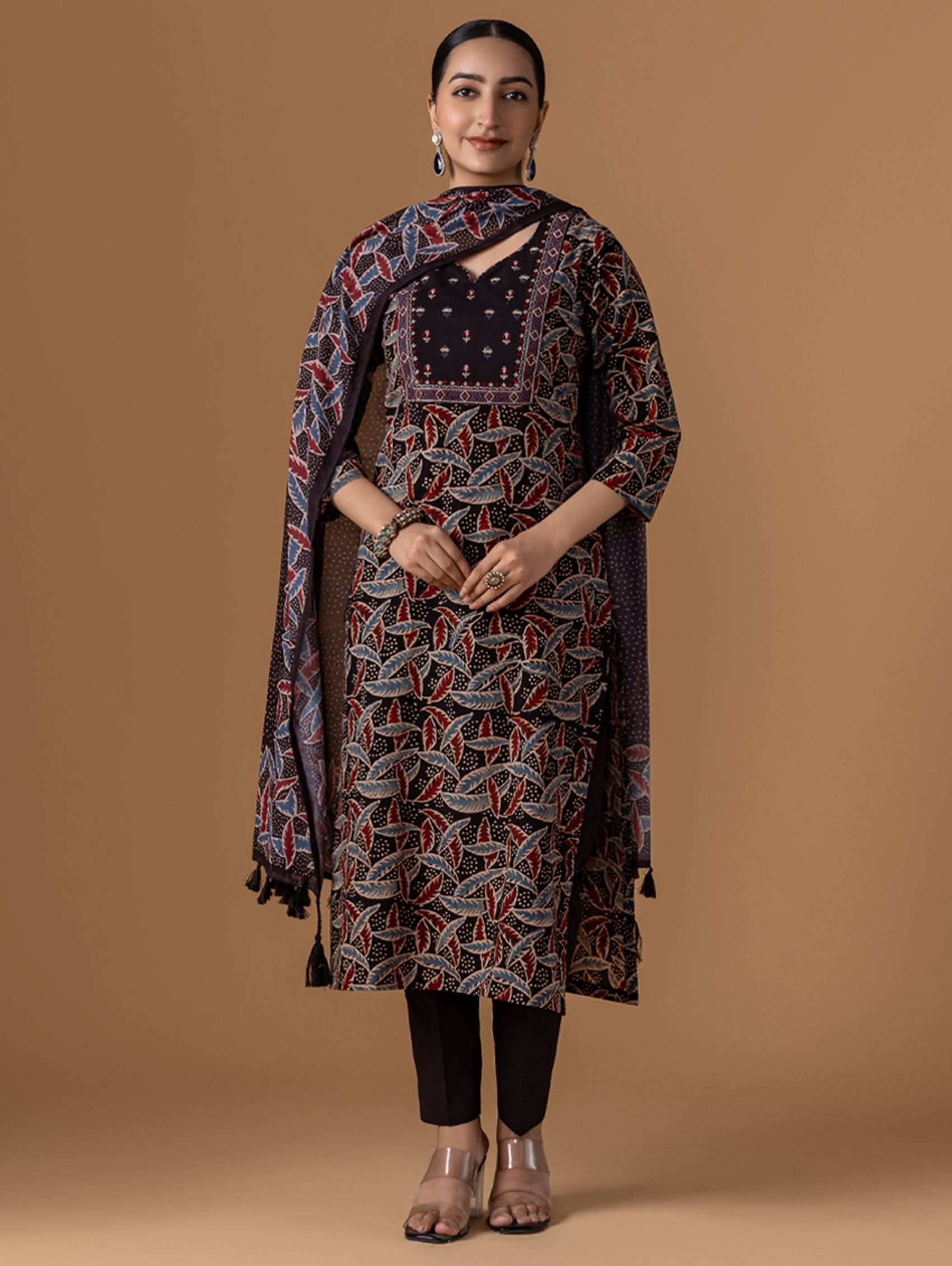 Woman wearing a patterned dress against a brown background
