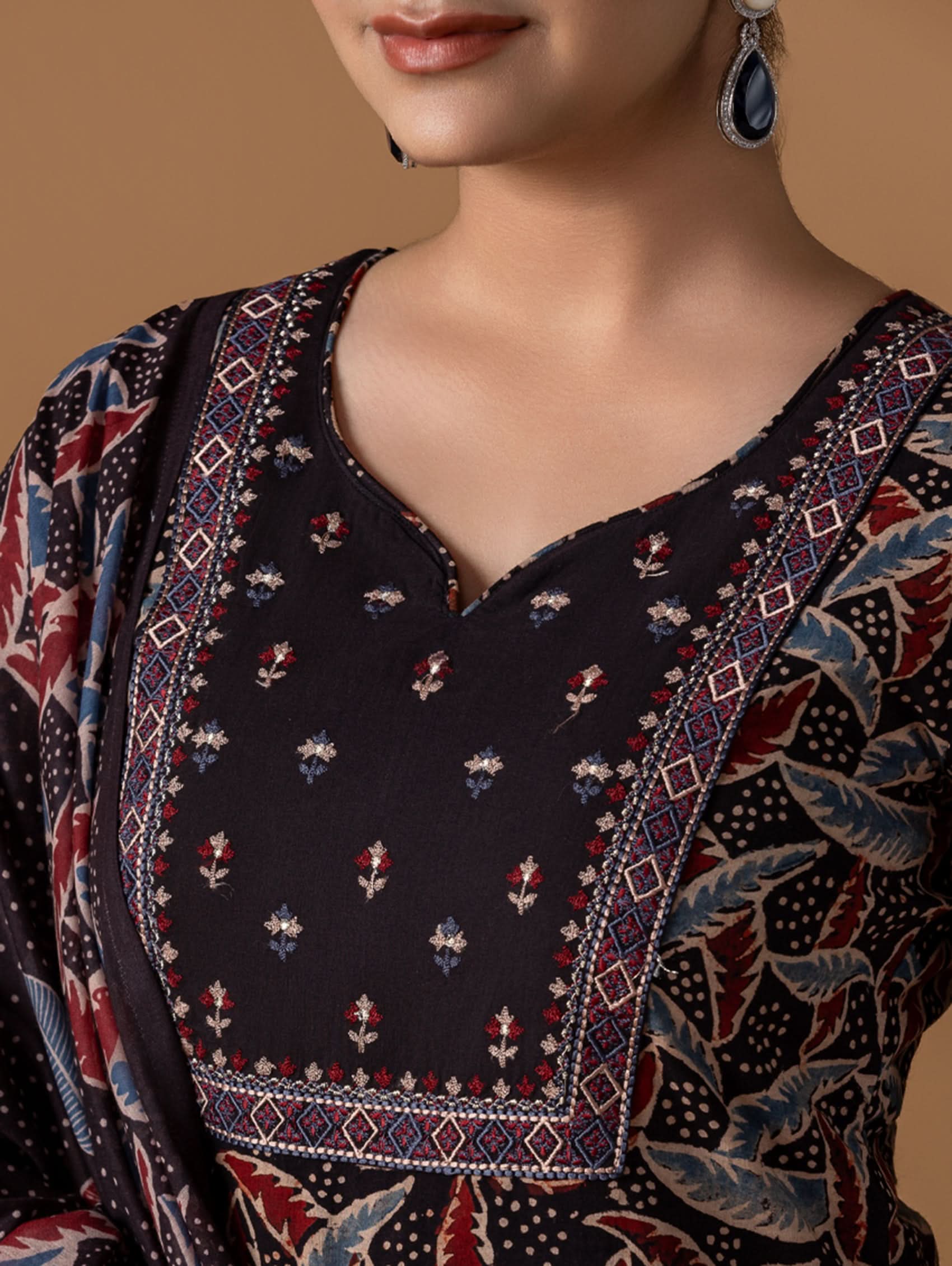 Close-up of a person wearing a patterned garment with a neutral background.