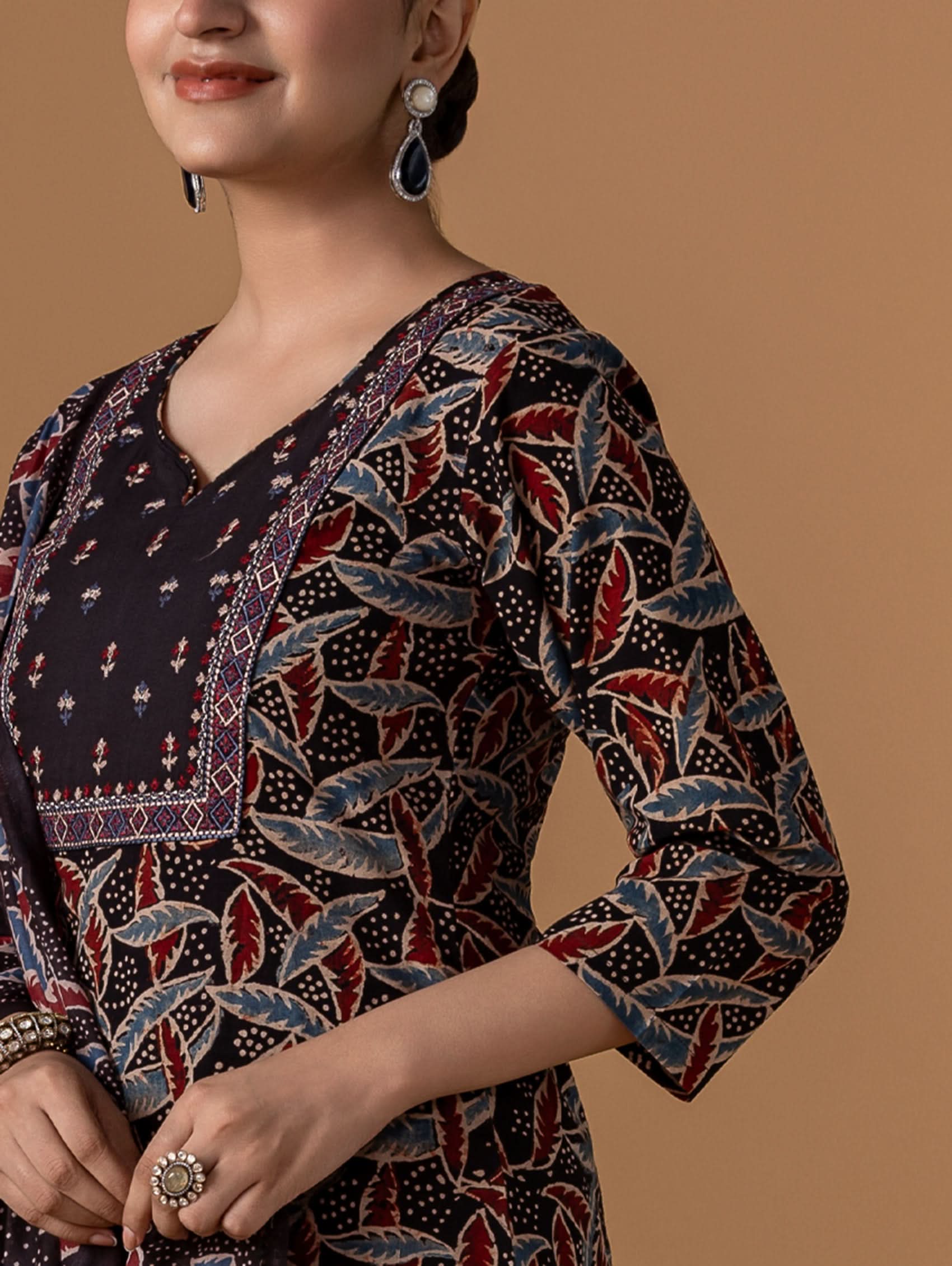 Person wearing a patterned garment with a brown background