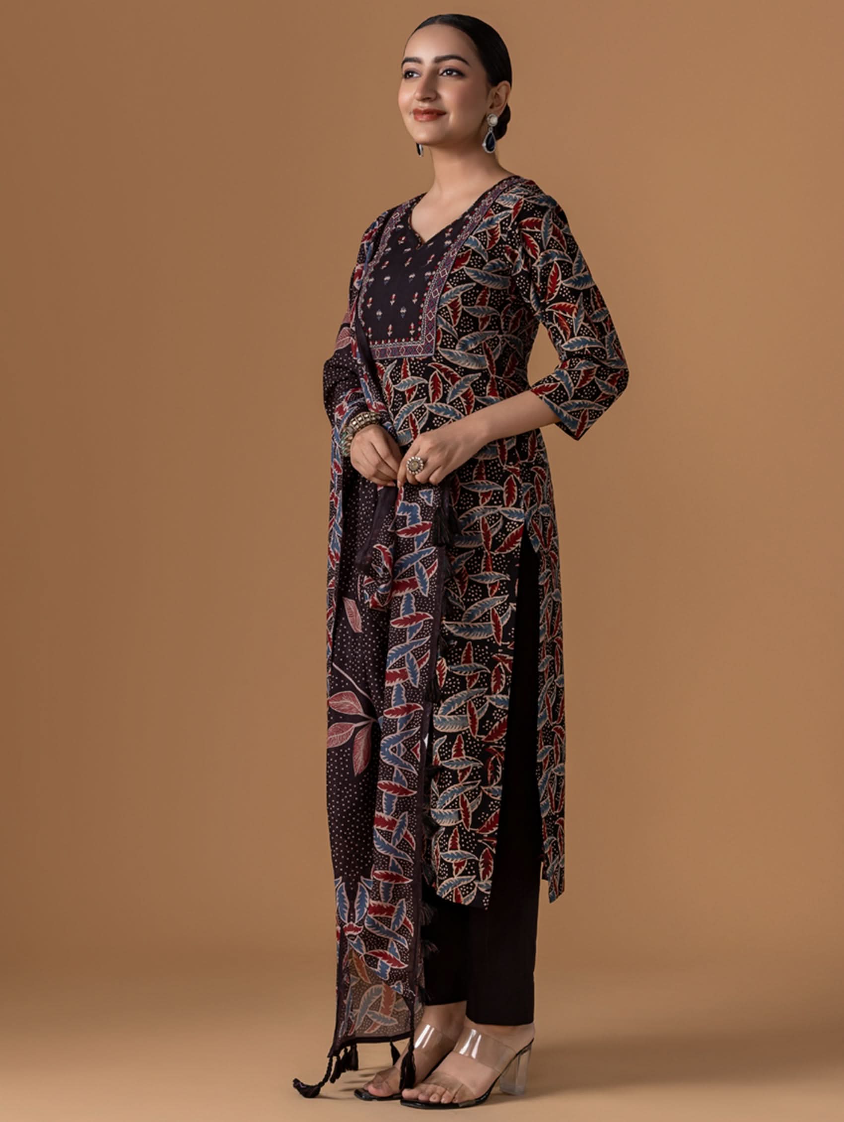 Woman wearing a patterned dress against a brown background