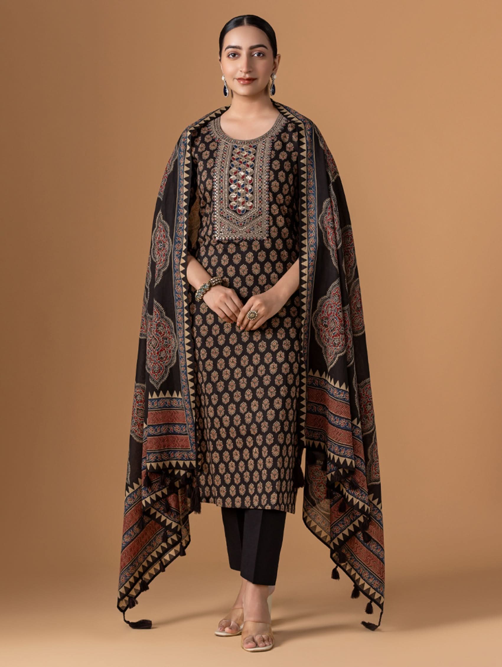 Woman wearing a traditional outfit with a patterned shawl on a beige background