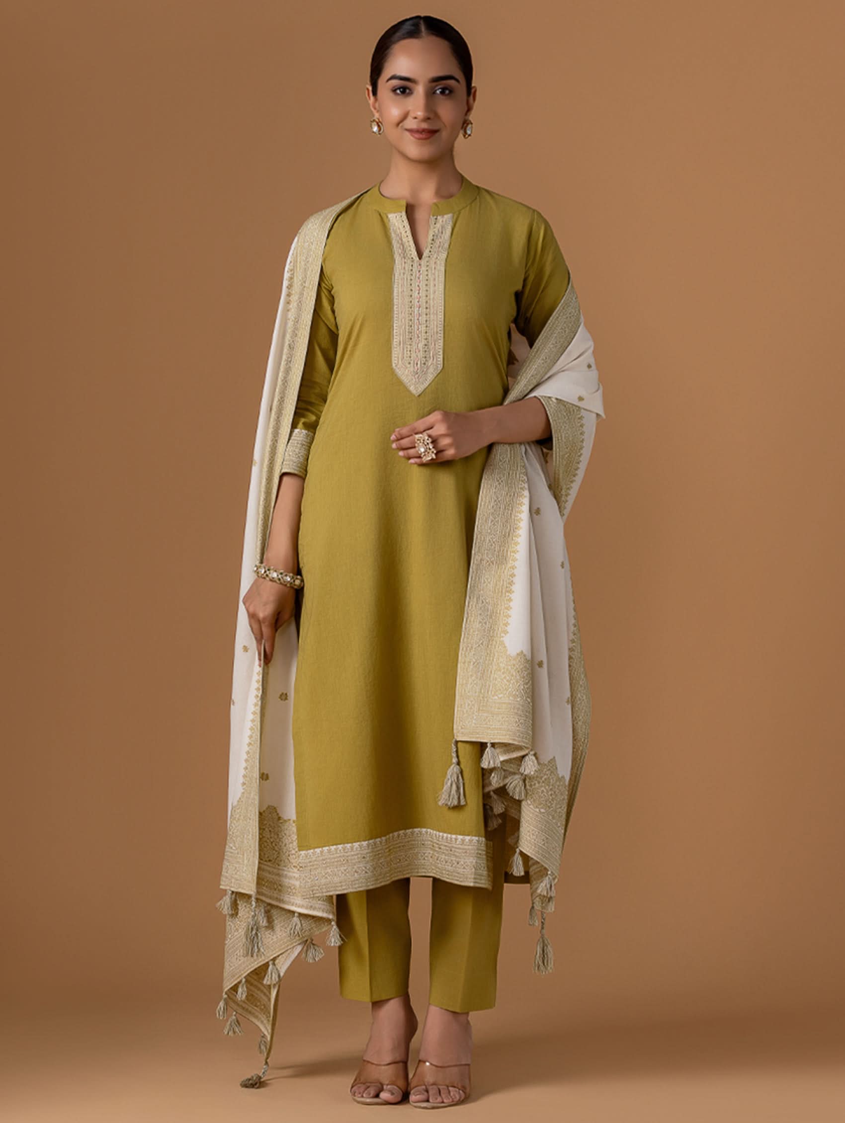 A woman wearing a green kurta with ban collar, three-fourth sleeves, and side slits, paired with straight pants, and a beige and gold jamdani pure cotton mul dupatta.